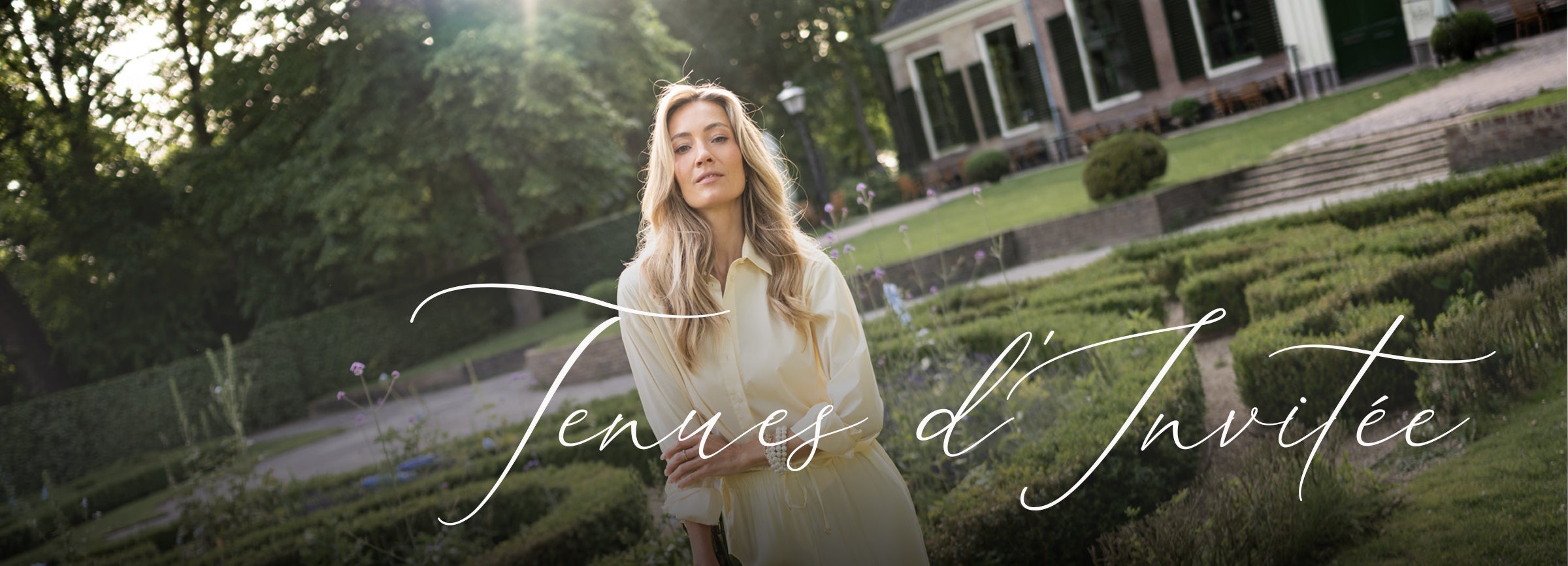 Light yellow dress displayed outdoors, shown front view on model. The dress features a soft color, feminine silhouette, and elegant styling suitable for special occasions.