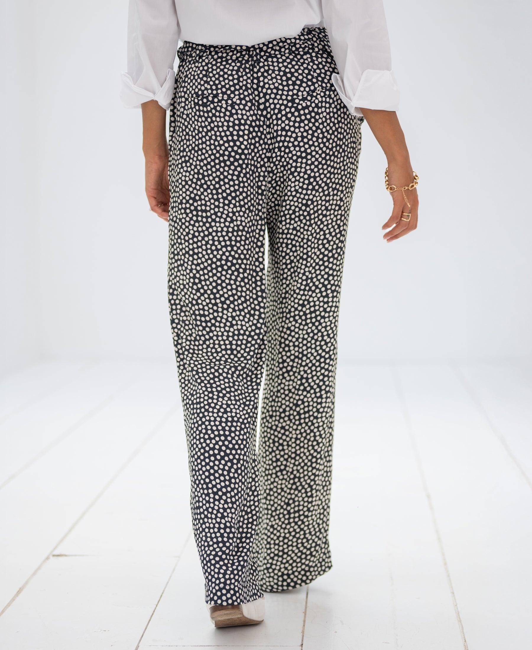 Charcoal-Ivory Stippenbroek LES ANDELYS pants shown from behind in a white room.