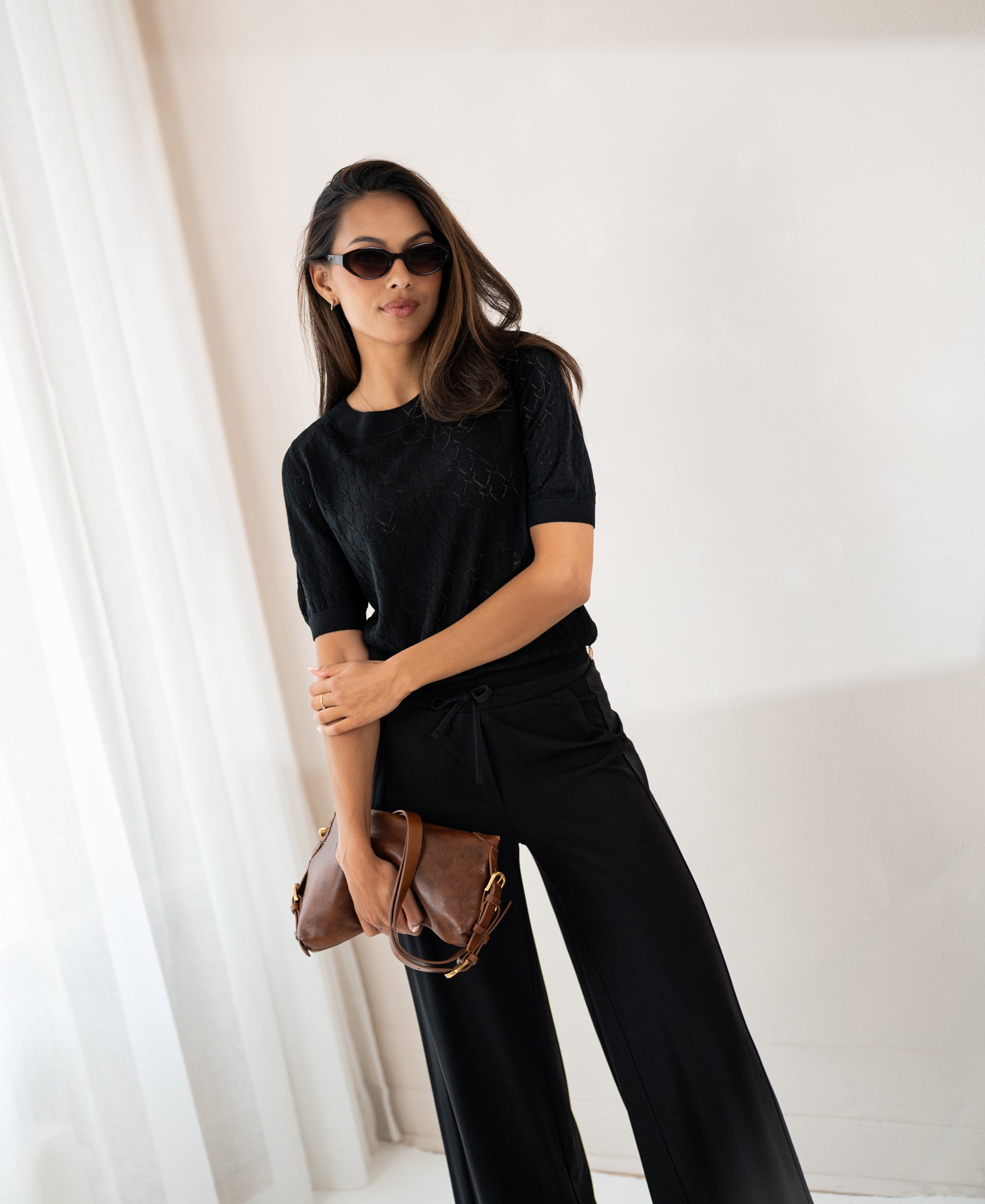 Black PLEIN PUBLIQUE sweater with heart pattern LE BATTANT worn by a woman indoors.