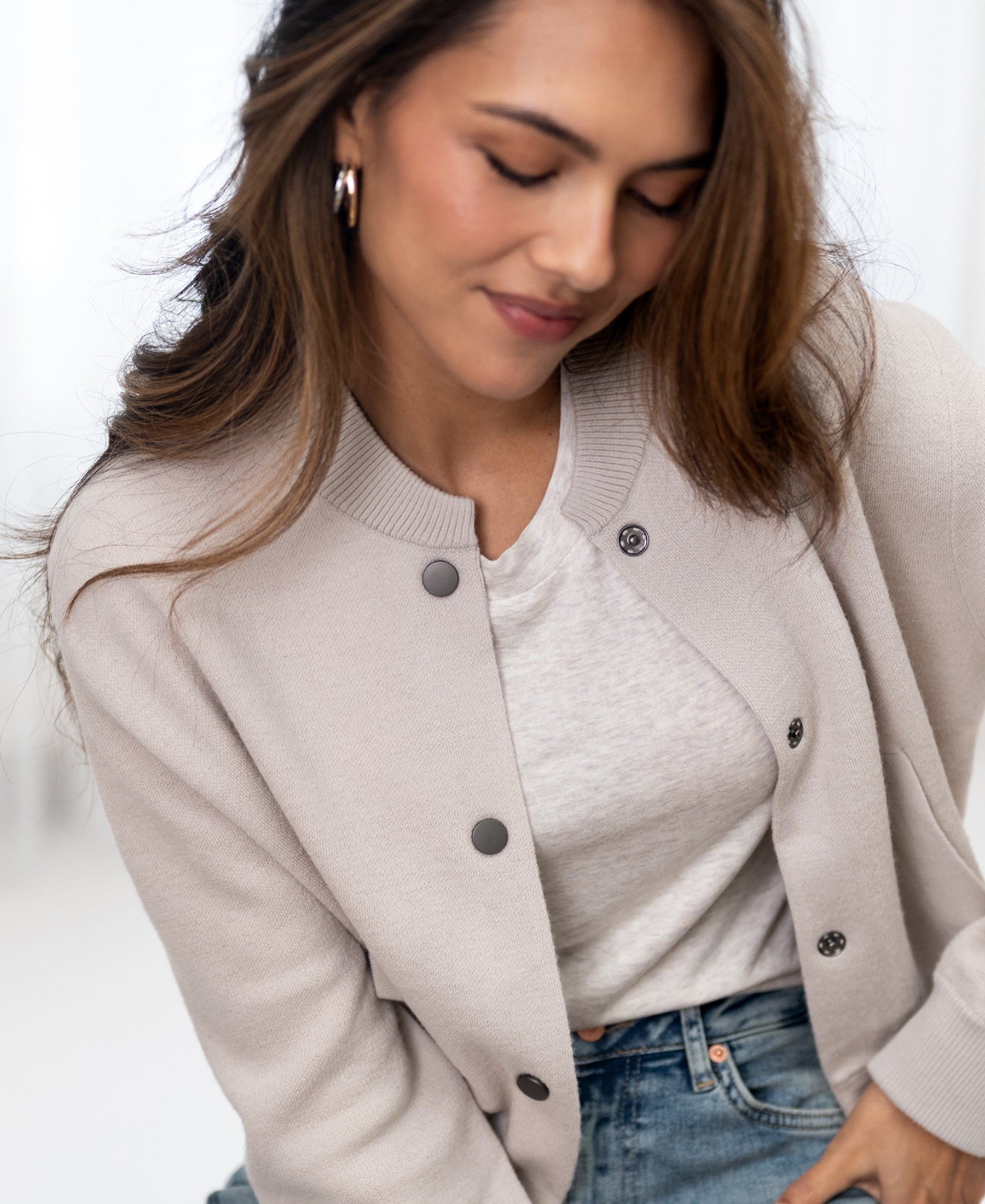 Beige bomber jacket in a relaxed fit, shown worn by a woman with long hair.