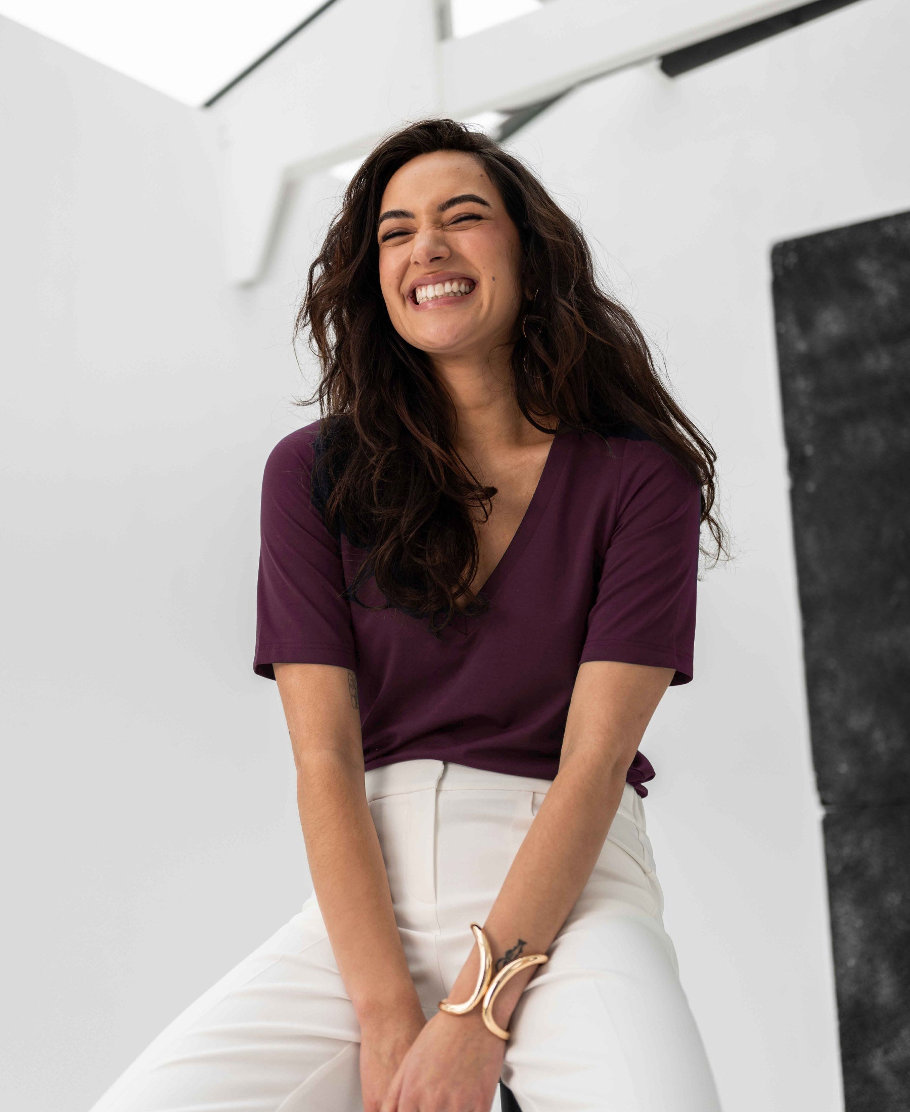 Bordeaux V-neck T-shirt by PLEIN PUBLIQUE, LA VERONIQUE style, shown in a bright, modern setting.
