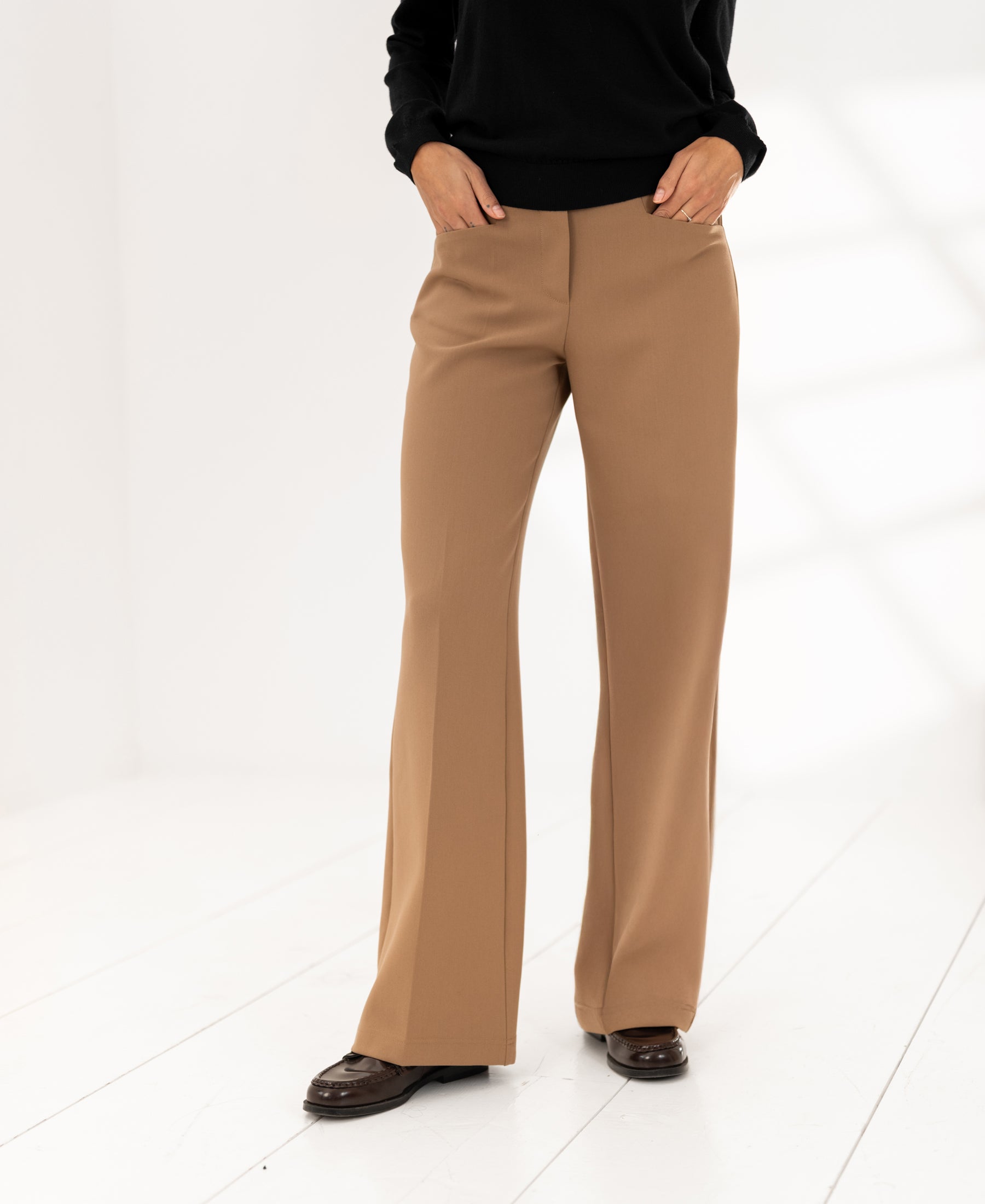 Wide-leg camel pants by LE CENTRE shown on a white floor in a bright room.