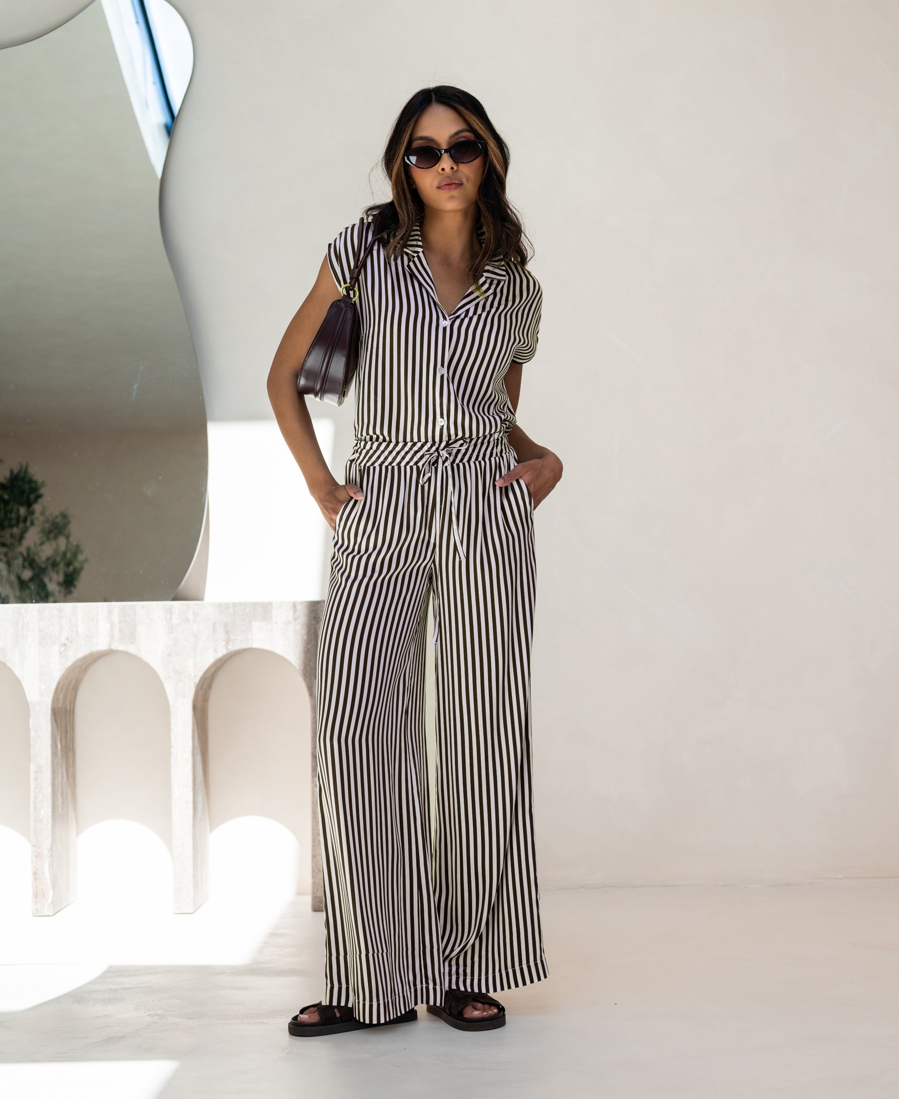 Striped ivory and cocoa blouse by PLEIN PUBLIQUE shown indoors.