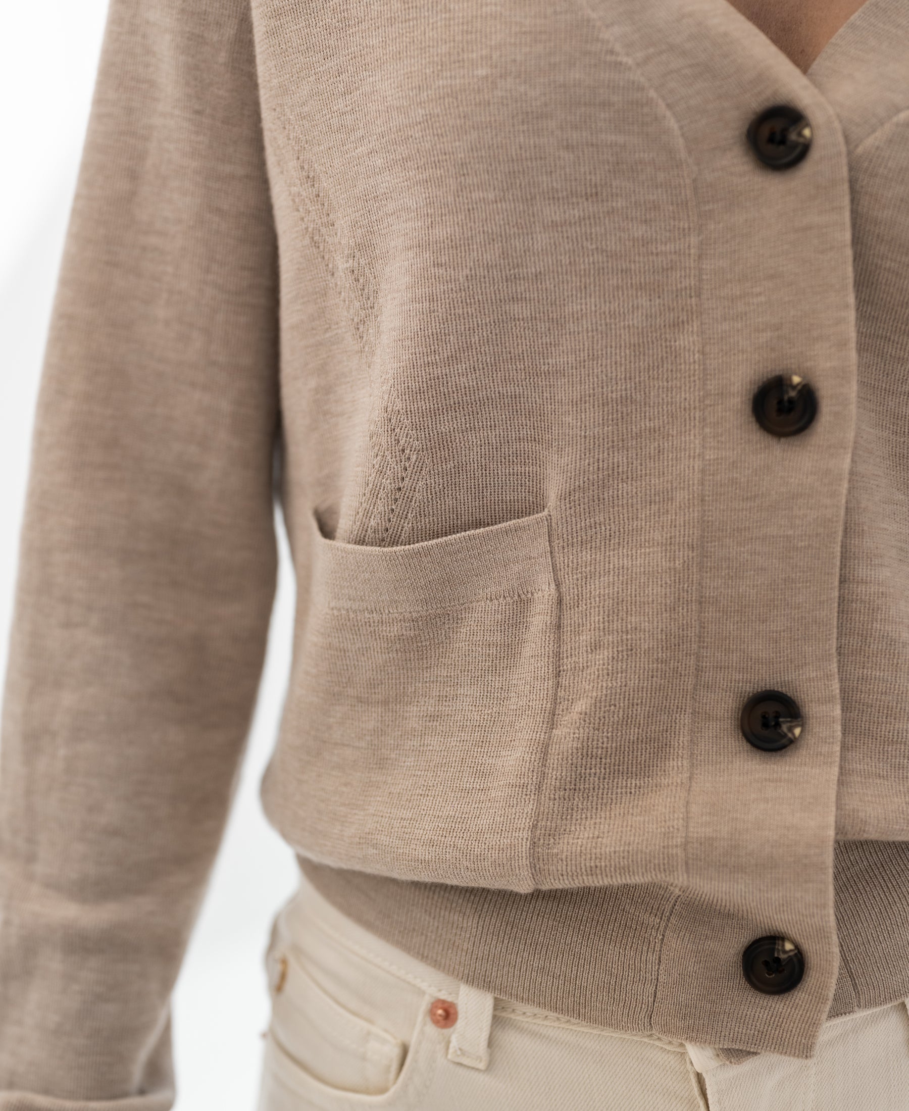 Close-up of the Merino wool vest "The Woman" in sand color by PLEIN PUBLIQUE with black buttons.
