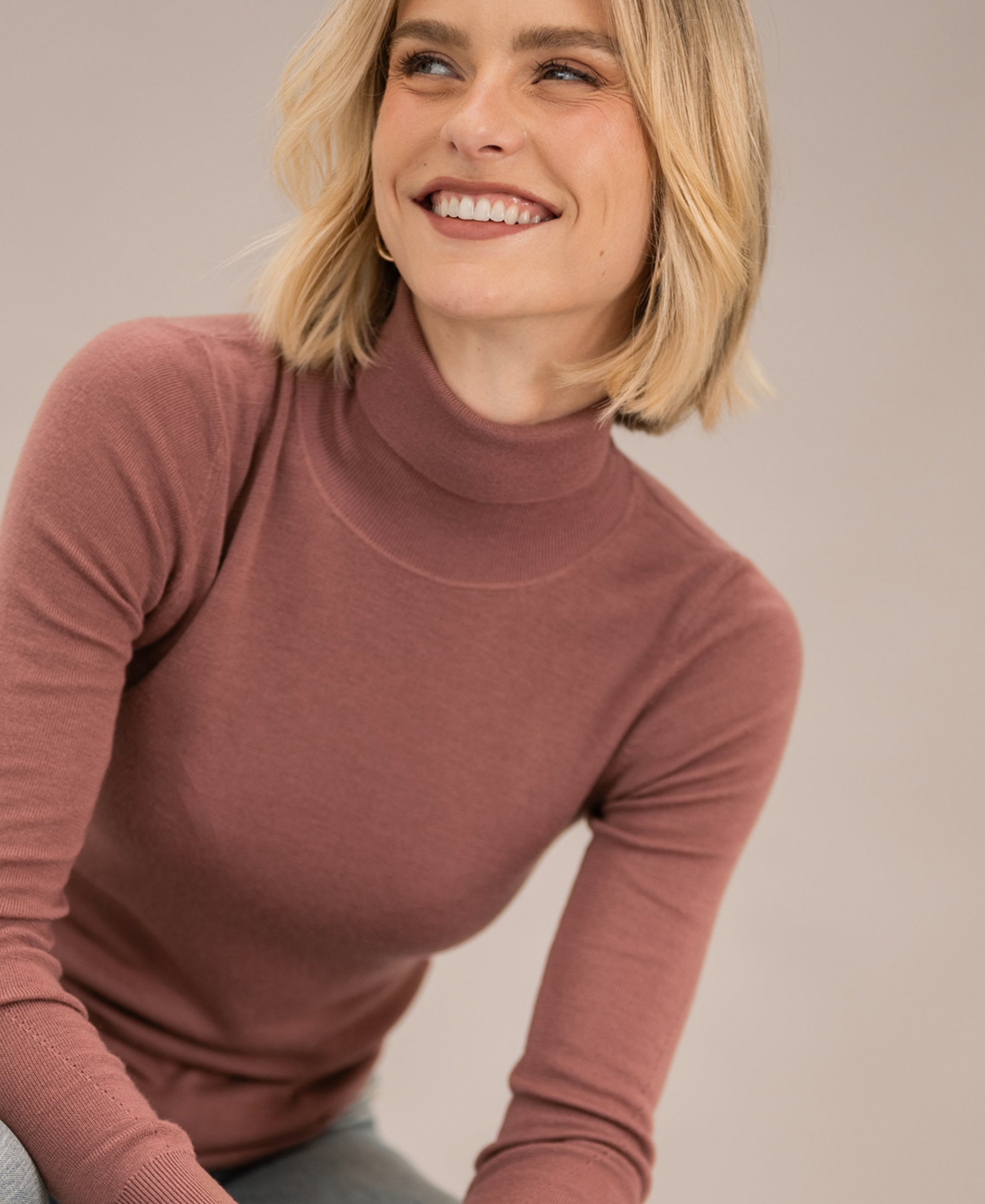 Dusty pink merino wool turtleneck sweater, front view.