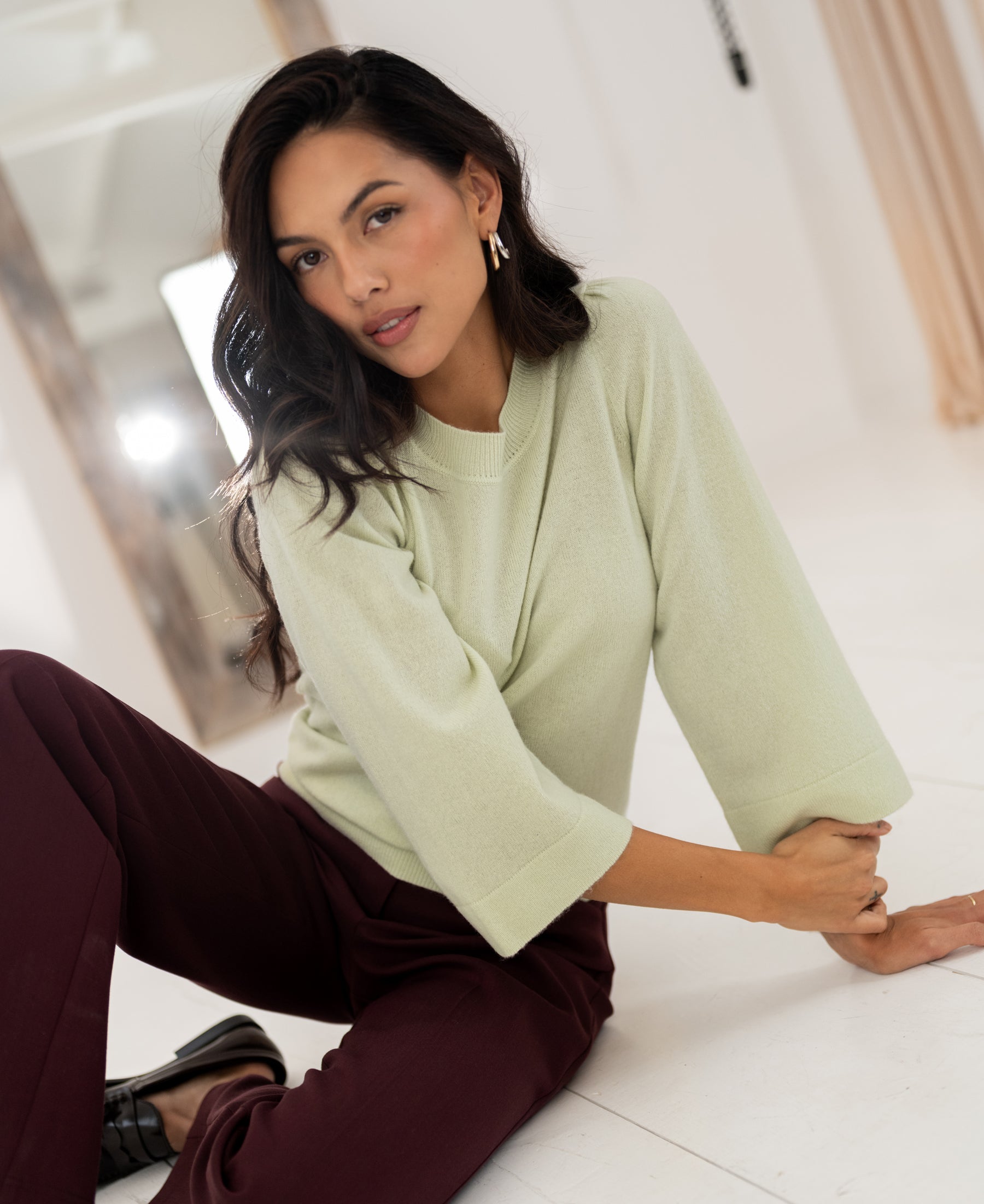 Light green merino wool sweater by PLEIN PUBLIQUE, shown on a white floor.