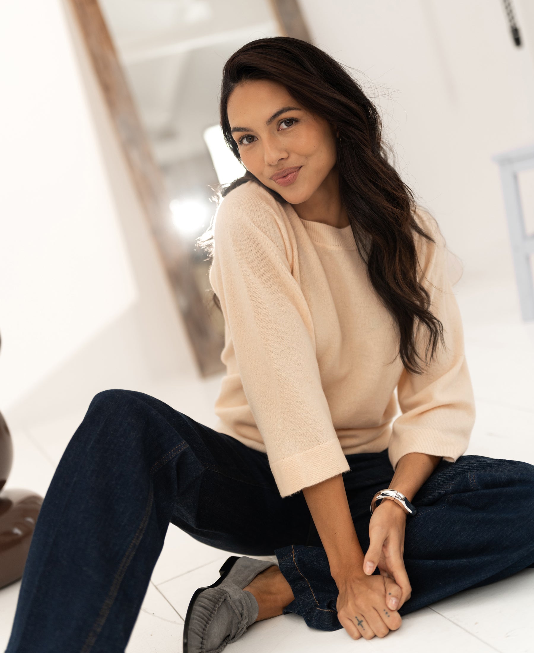 Woman wearing a butter yellow merino wool sweater indoors.