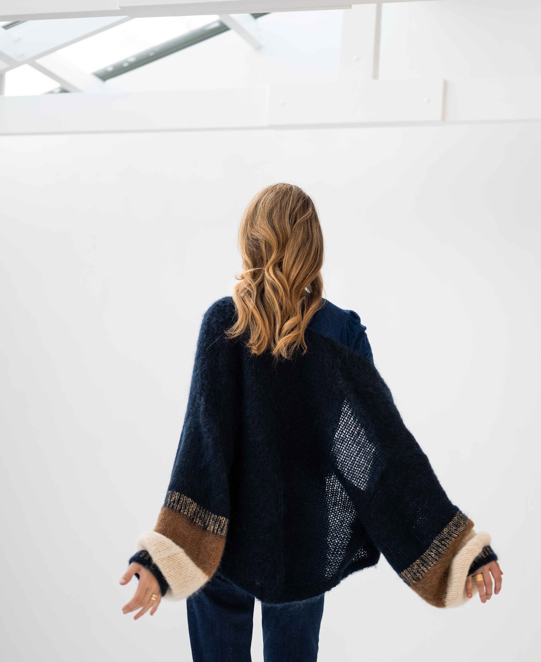 Rear view of a person wearing the fluffy vest LA BONBON Dark Blue by PLEIN PUBLIQUE.