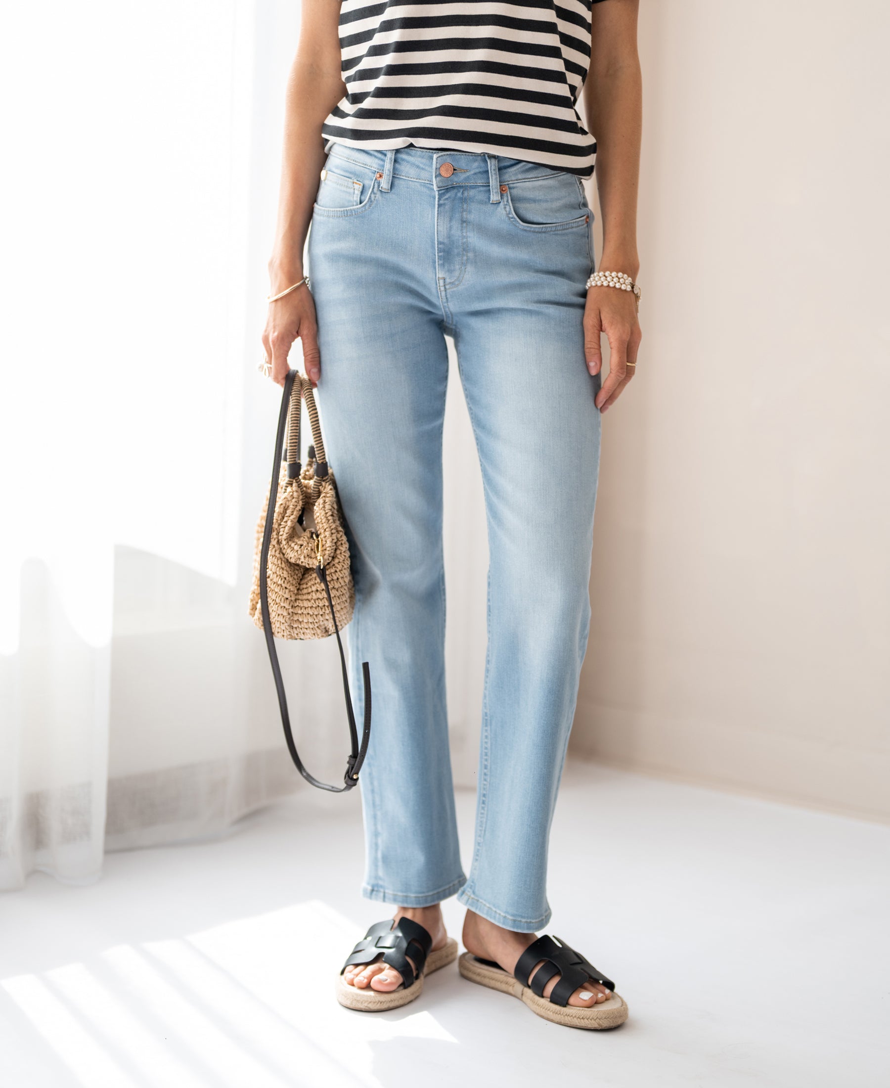 Person wearing light blue bleached cropped jeans.