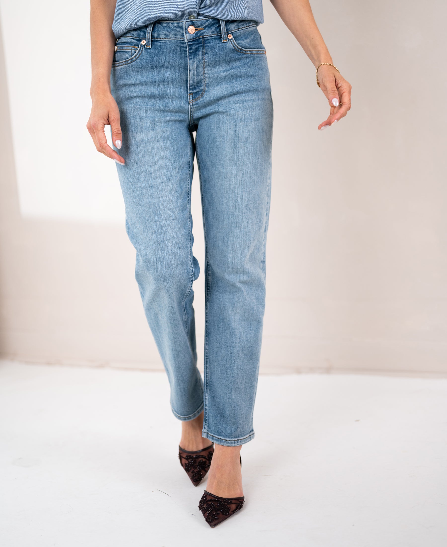 Light stone-washed cropped jeans made of denim, shown from the waist down, upper body out of frame.