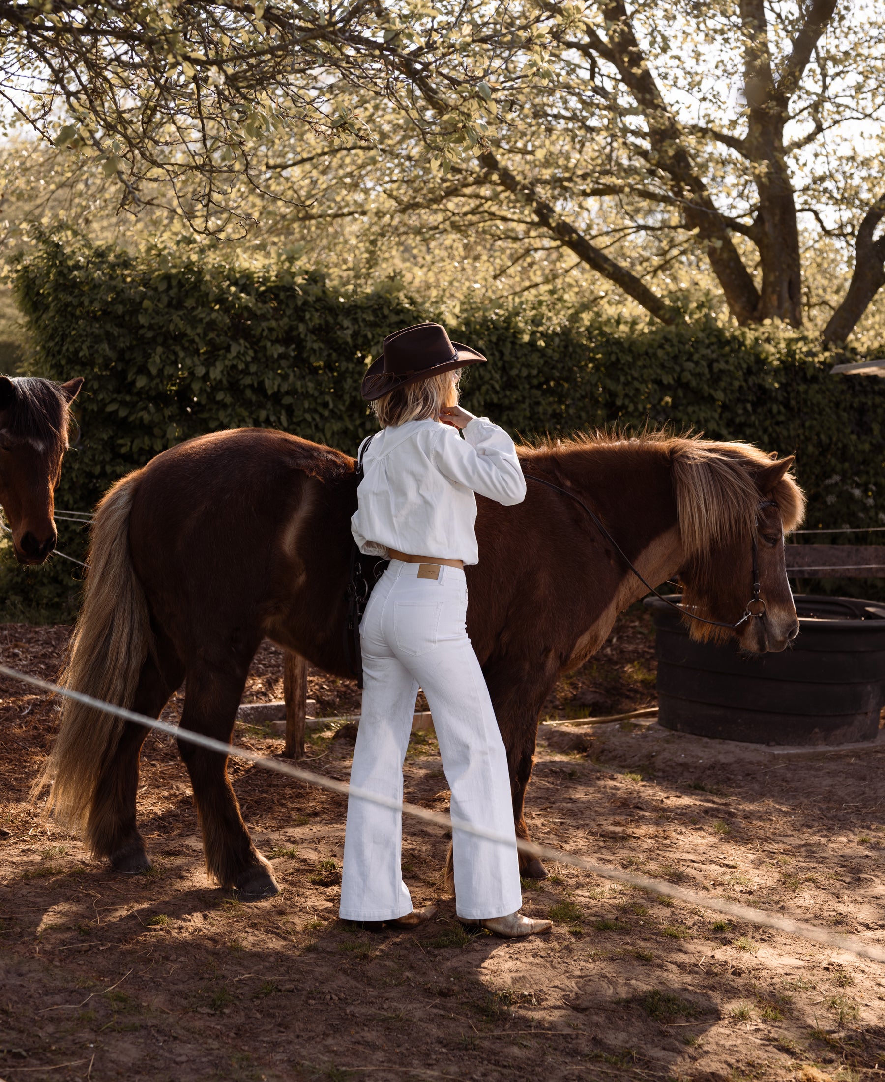 White wide leg jeans from PLEIN PUBLIQUE shown outdoors on a sunny day.