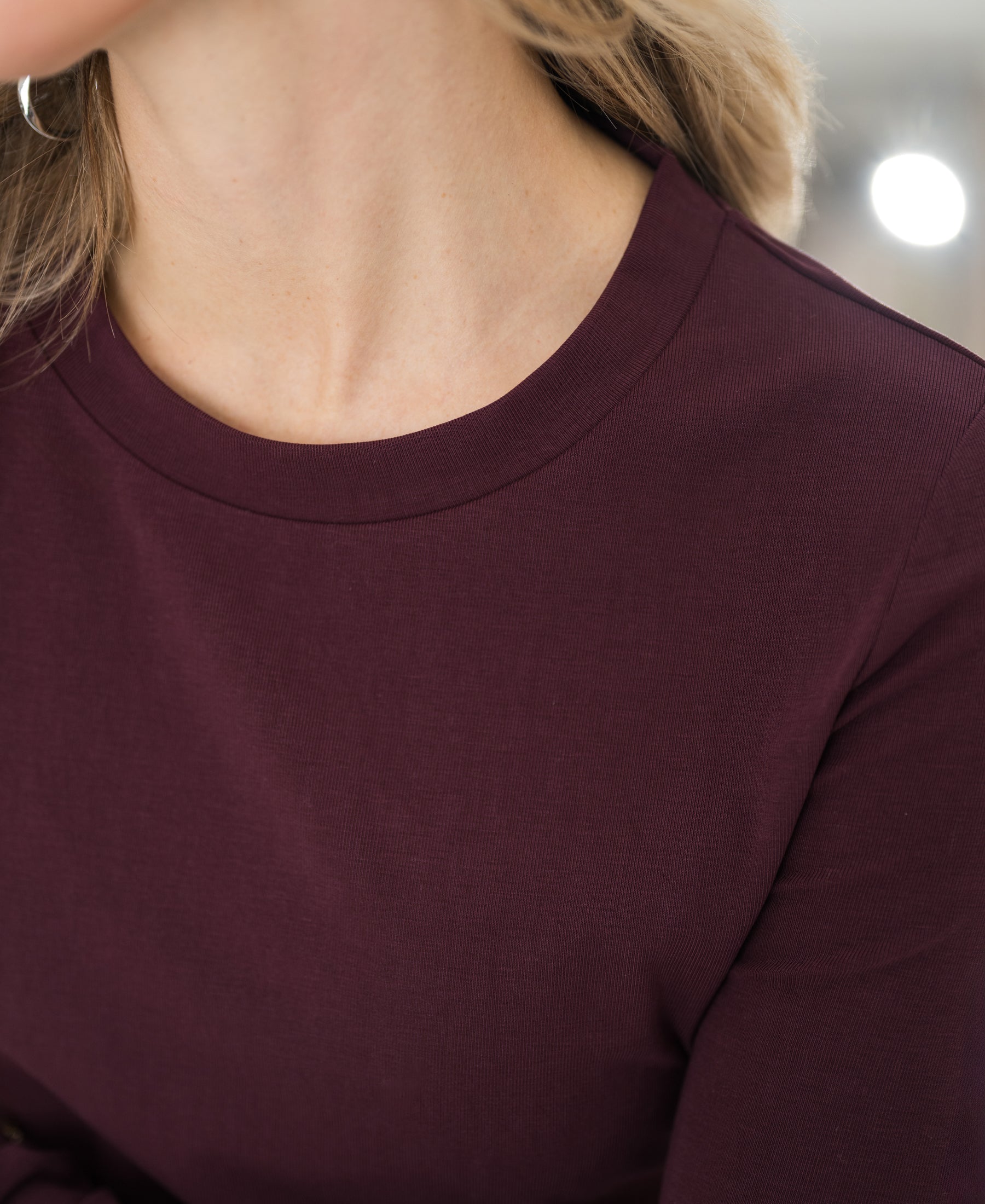 Close-up of the Luxe long sleeve LA JANE T-shirt in wine color, showing neck and shoulder.