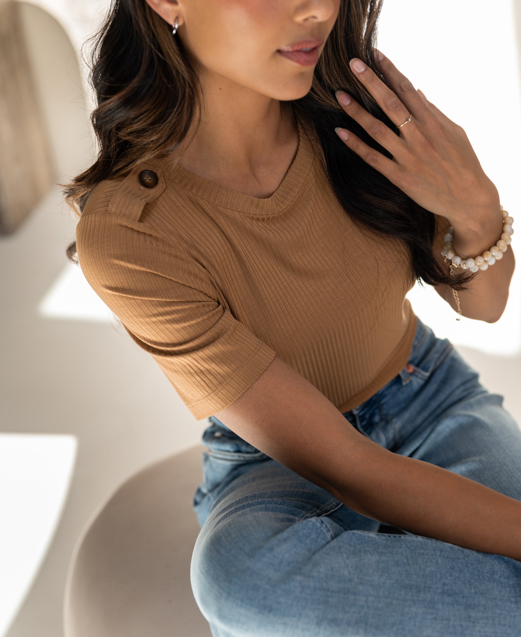 Woman wearing a bamboo T-shirt in garden yellow by PLEIN PUBLIQUE, shown in soft light.