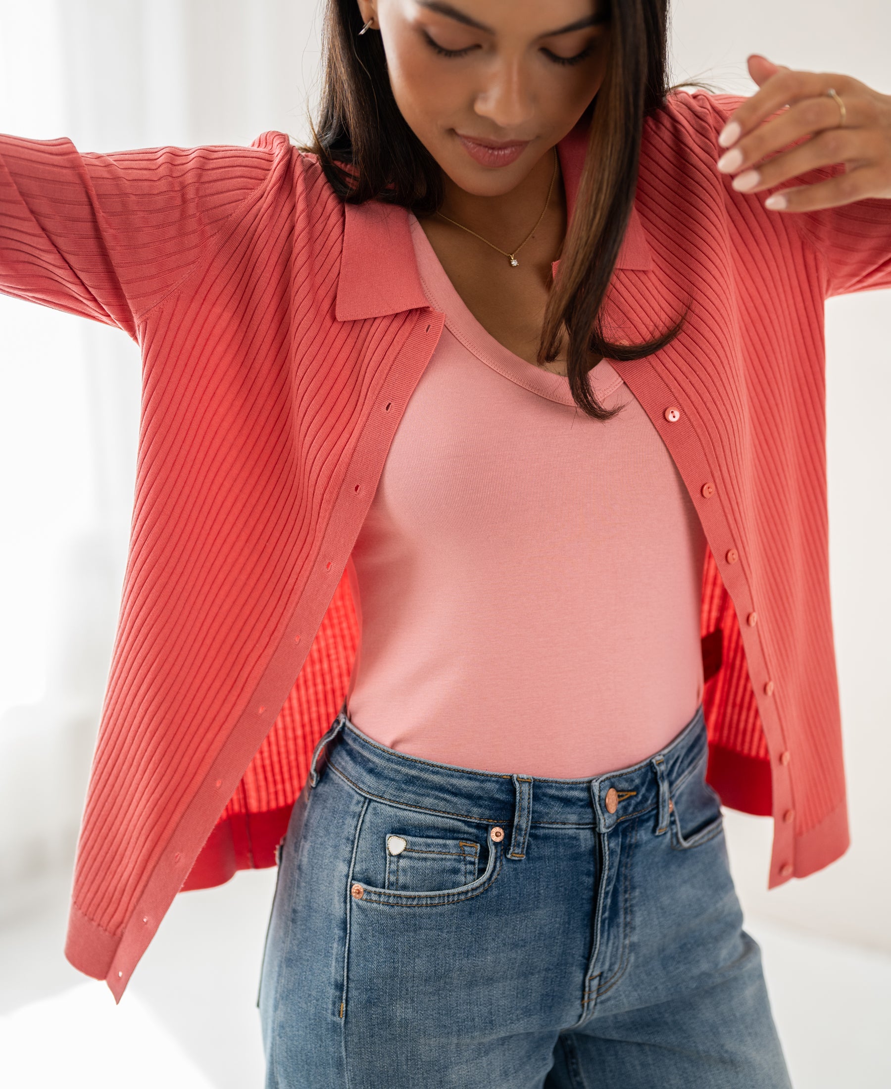 Tencel-silk ribbed vest in flamingo pink by PLEIN PUBLIQUE, shown indoors with model’s arms slightly raised.