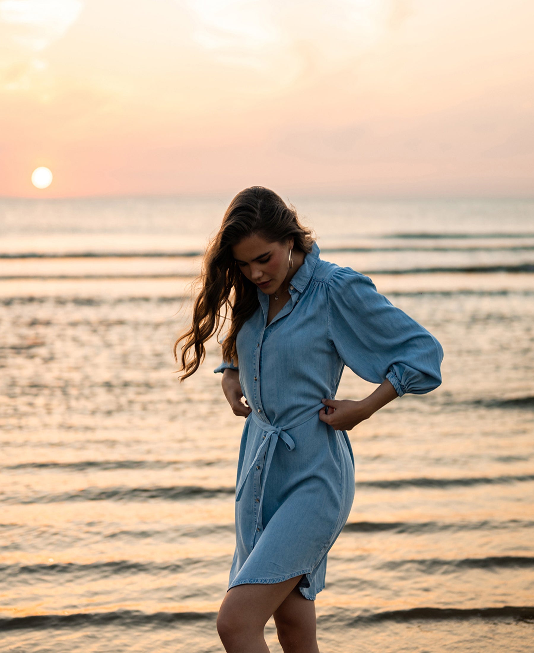 Tencel blouse dress in bleached color by PLEIN PUBLIQUE, shown at the beach at sunset.