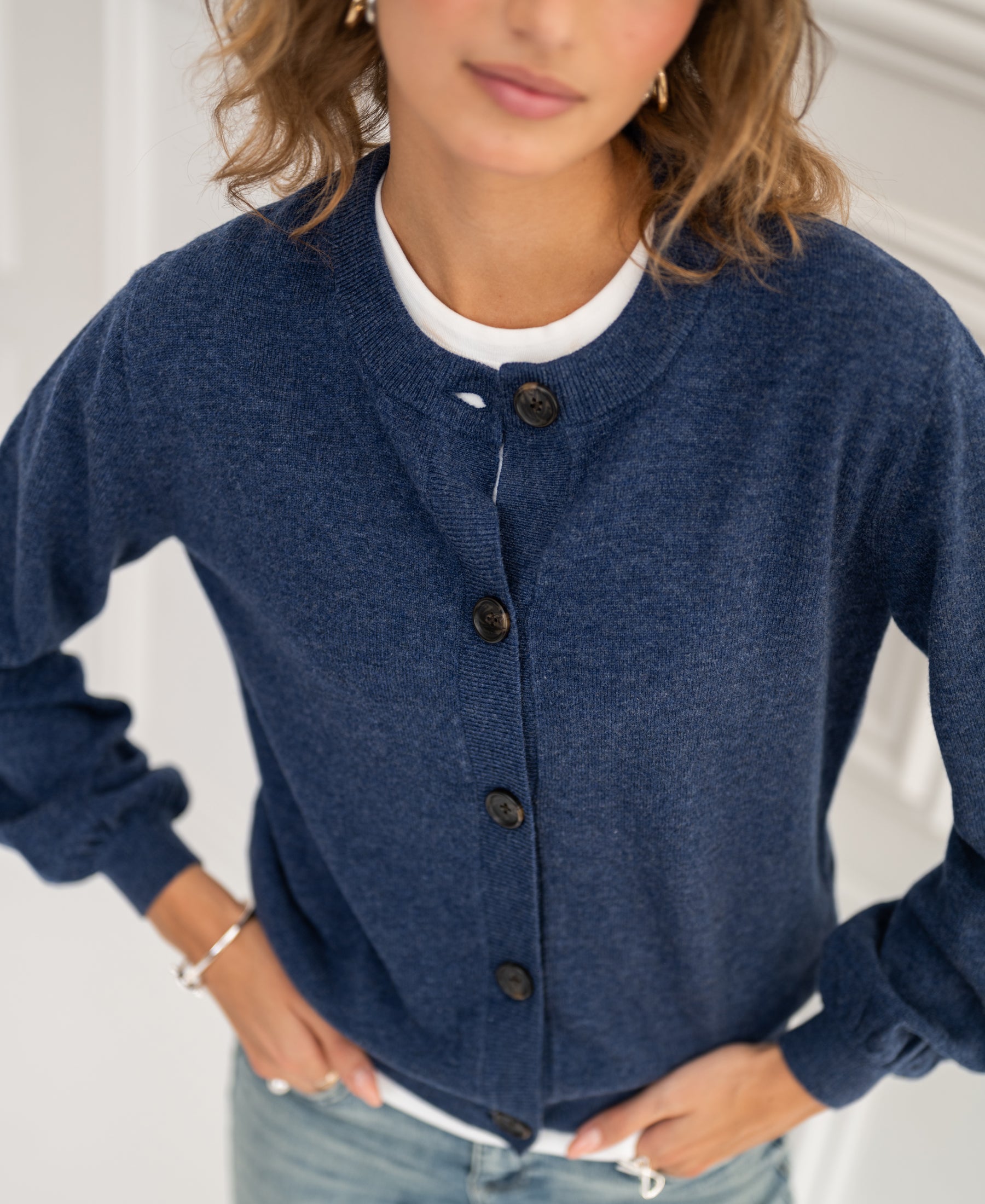 Crew neck cardigan LA LEA by PLEIN PUBLIQUE in indigo blue, model with hand on hip, face blurred.