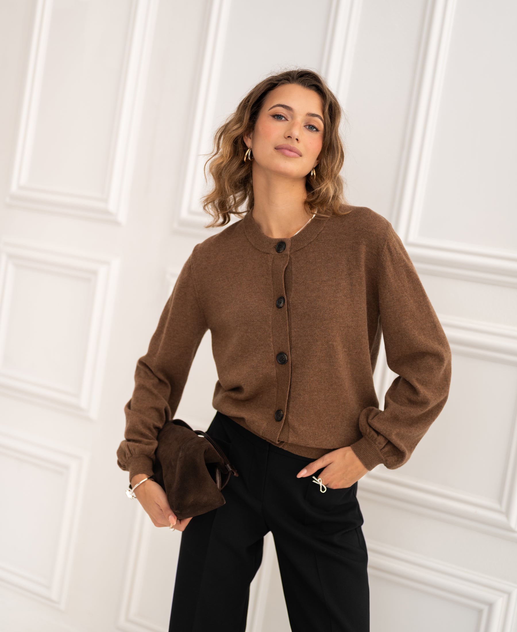 PLEIN PUBLIQUE round neck cardigan LA LEA in tobacco color, shown against a white panel wall.