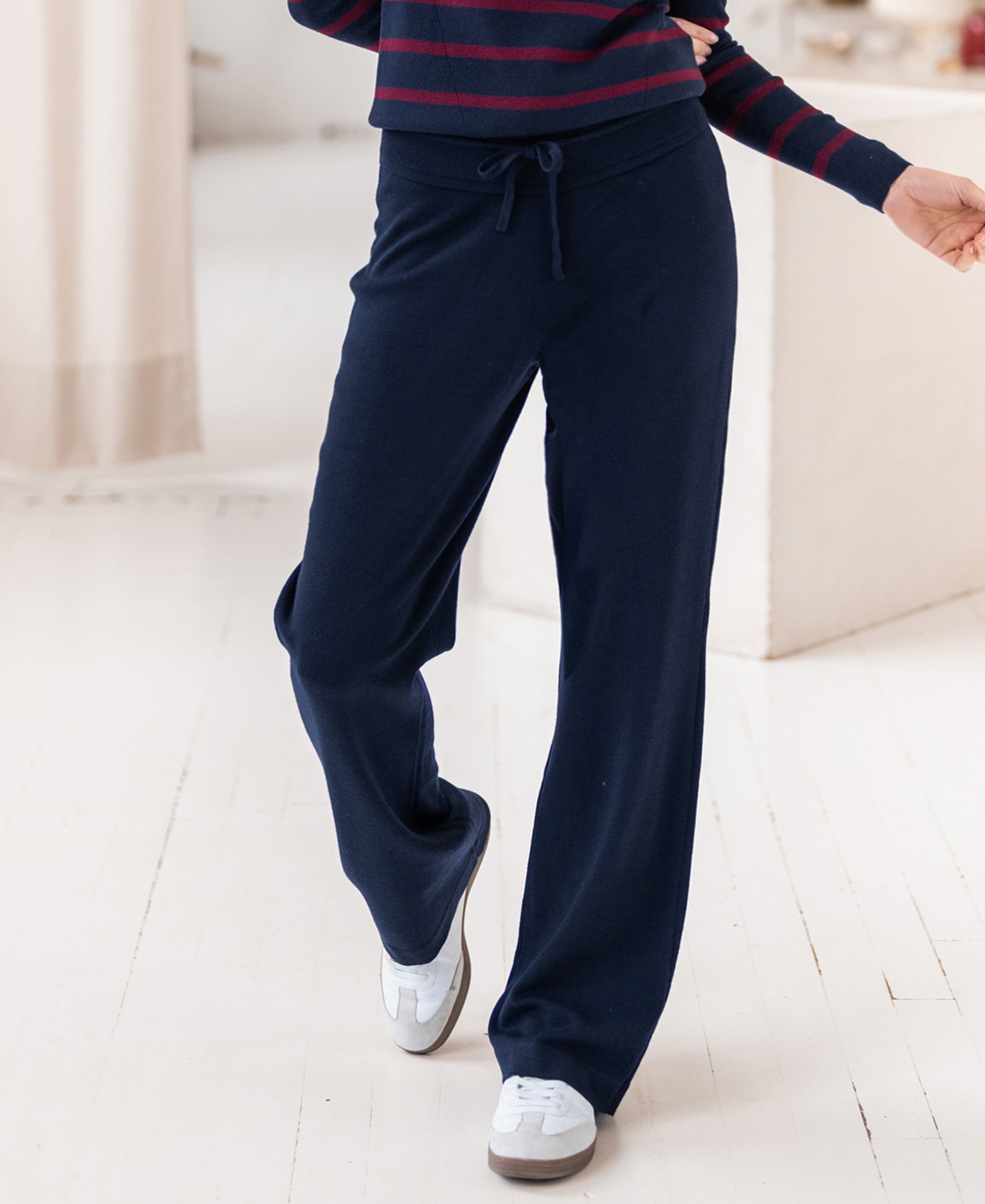 Person wearing navy knitted pants indoors.
