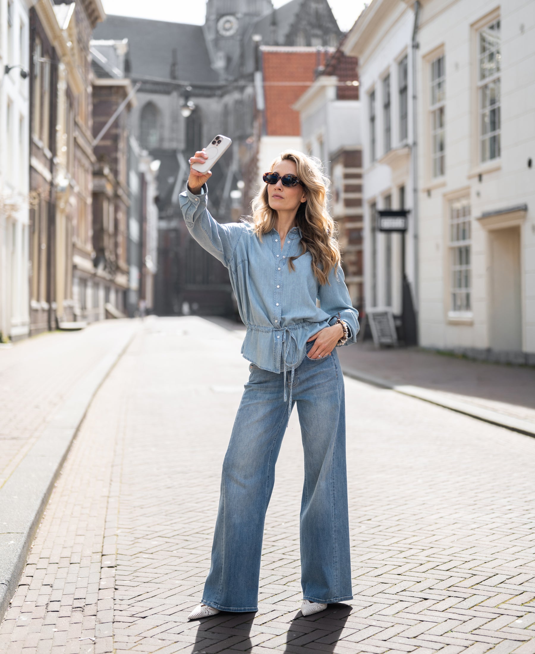 Woman wearing a light blue Tencel denim blouse with snaps.
