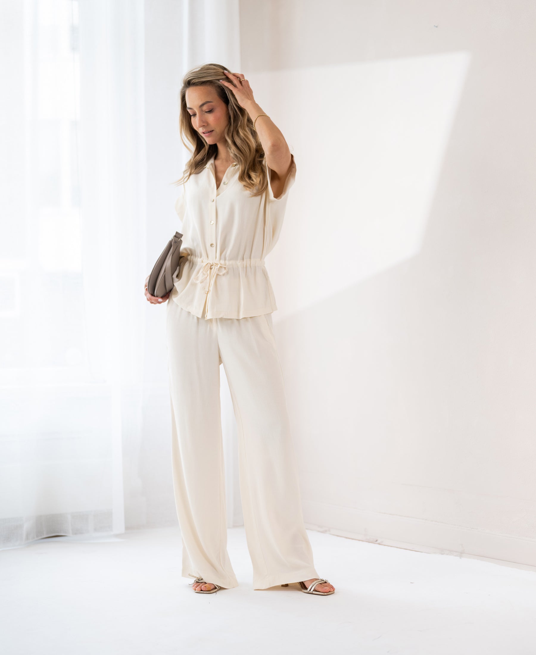 Cream wide-leg pants shown in a bright room.
