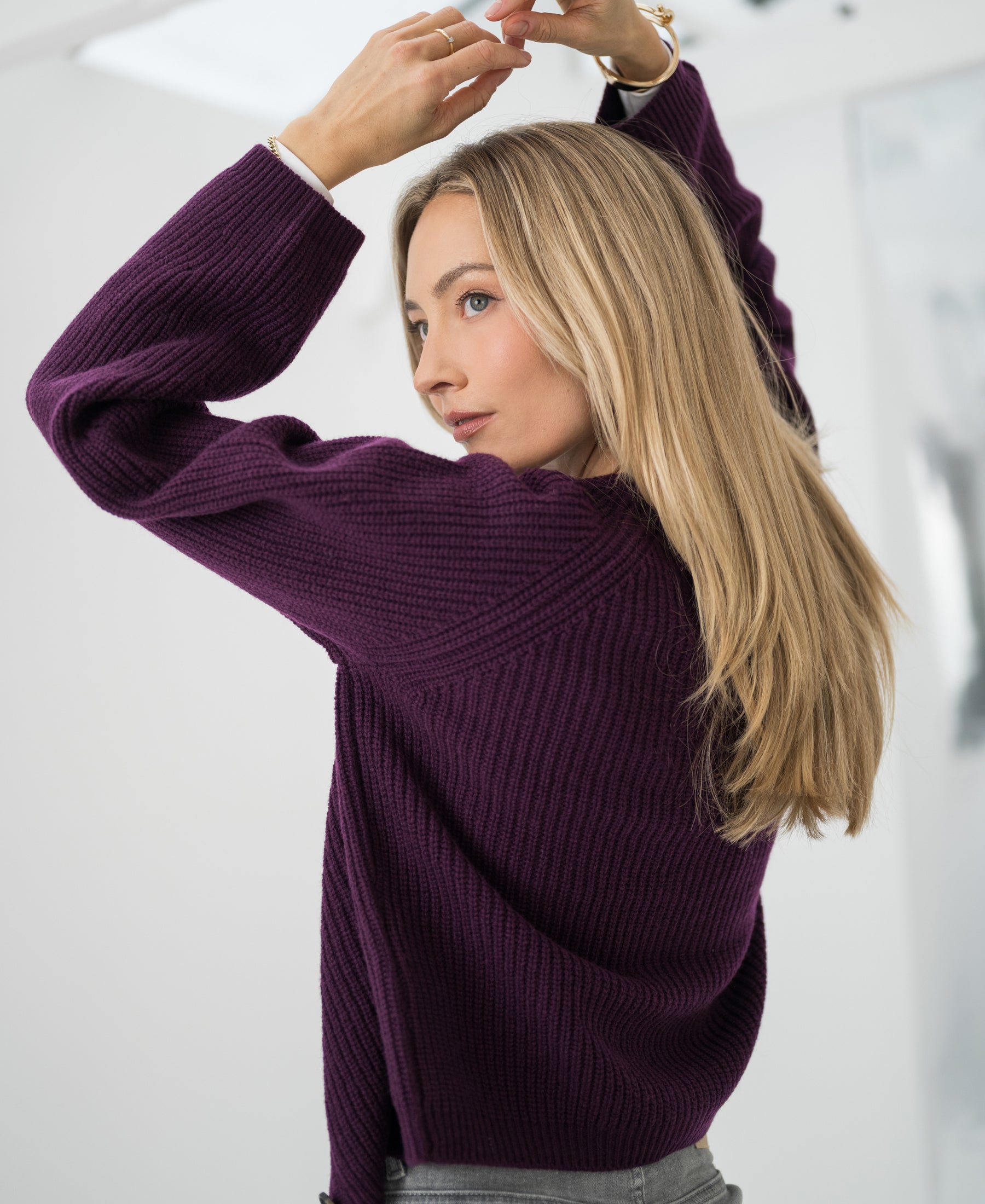 Merino wool vest in cassis color, shown in a bright modern room.