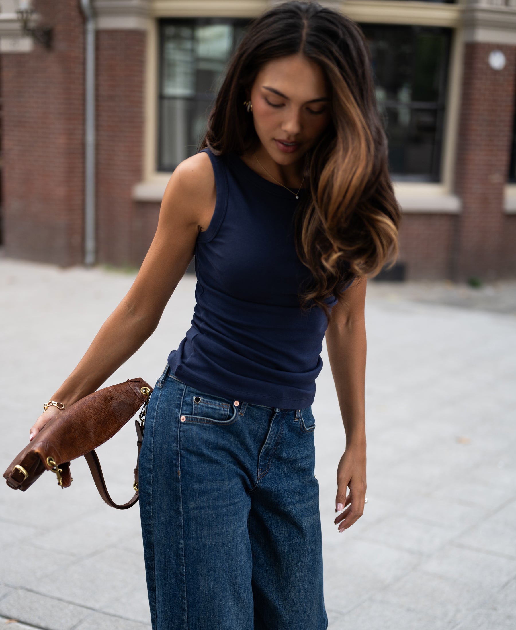 Navy blue luxe and soft boatneck top in a sidewalk setting.