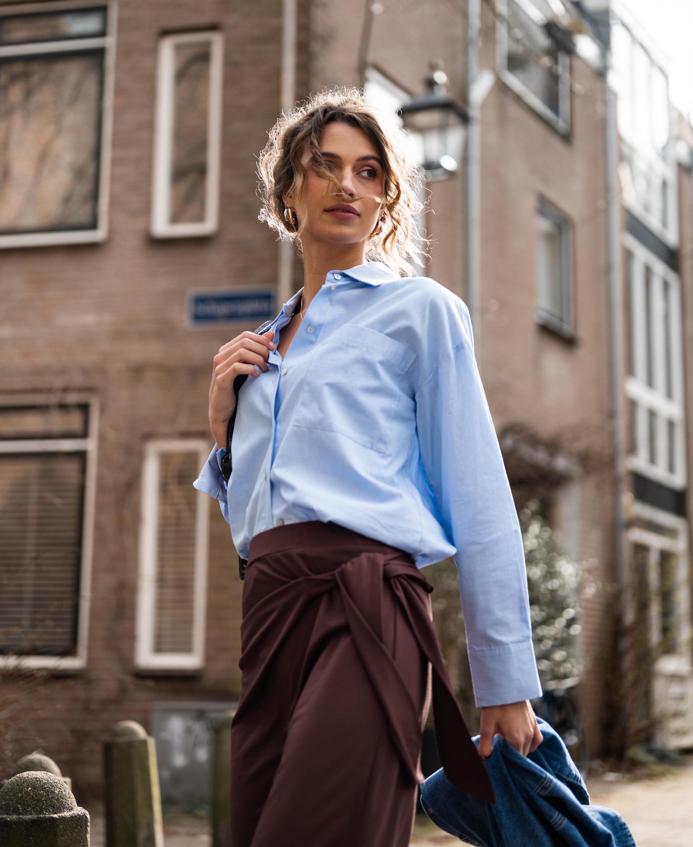 Model wears the PLEIN PUBLIQUE LA PASCALLE blouse, light blue striped.