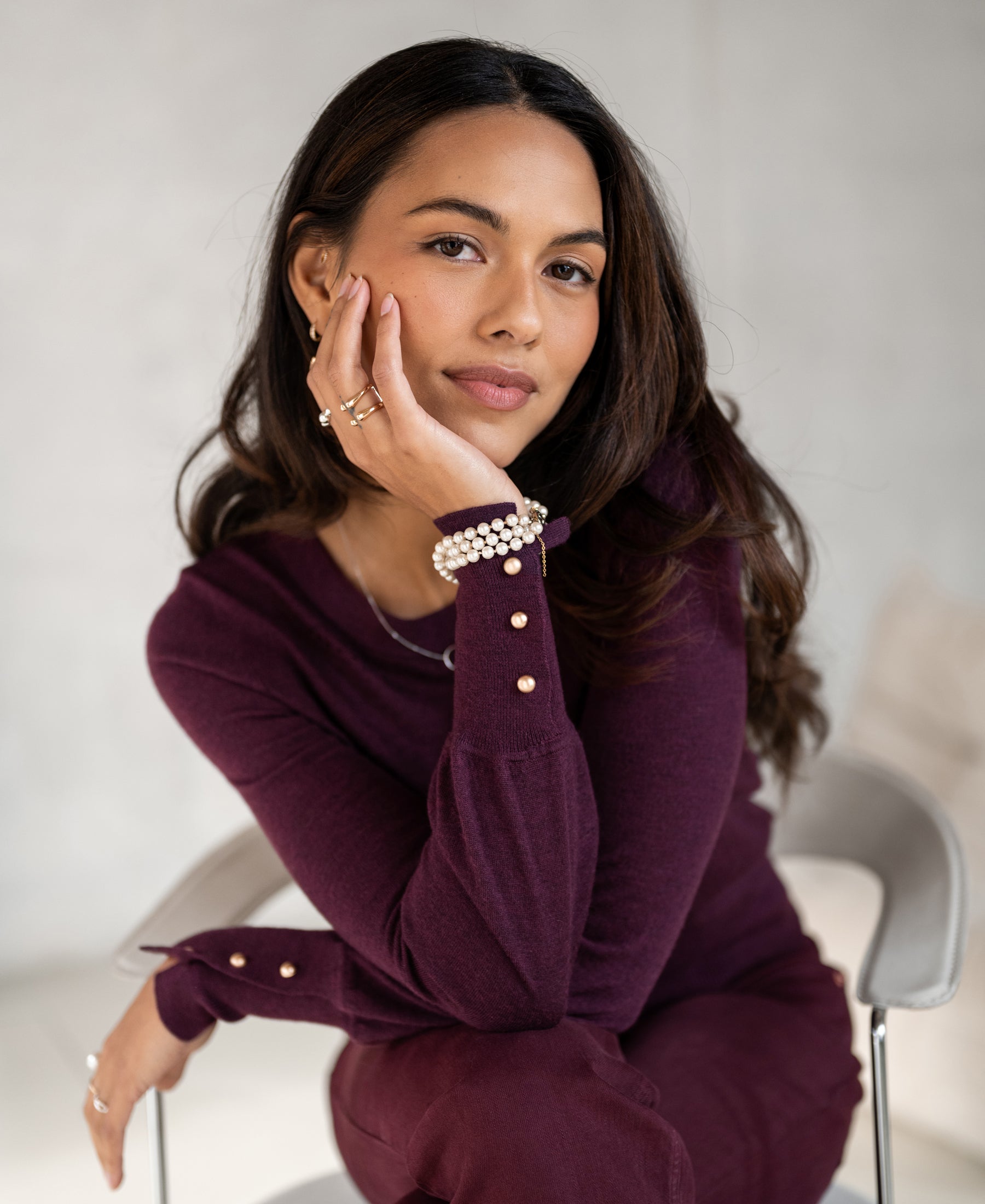 Woman wearing the PLEIN PUBLIQUE Merino wool sweater LA MARIS in Wine-Gold, facing the camera.
