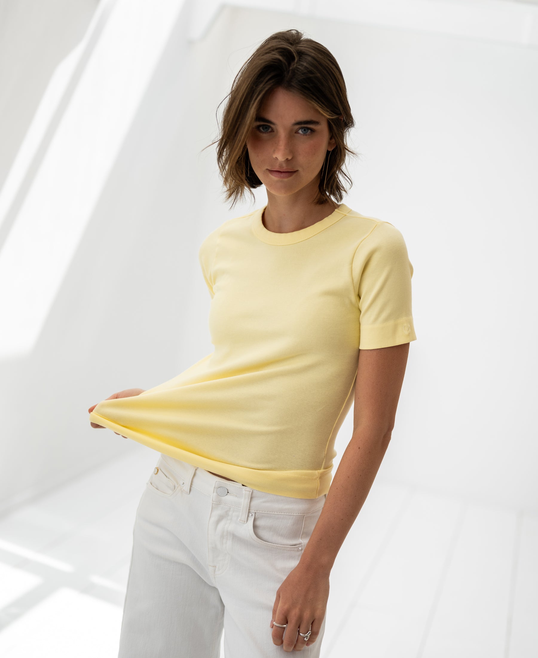 Luxe & Soft T-shirt LA MASSY Soft Yellow by PLEIN PUBLIQUE, shown in a bright, minimalist room.