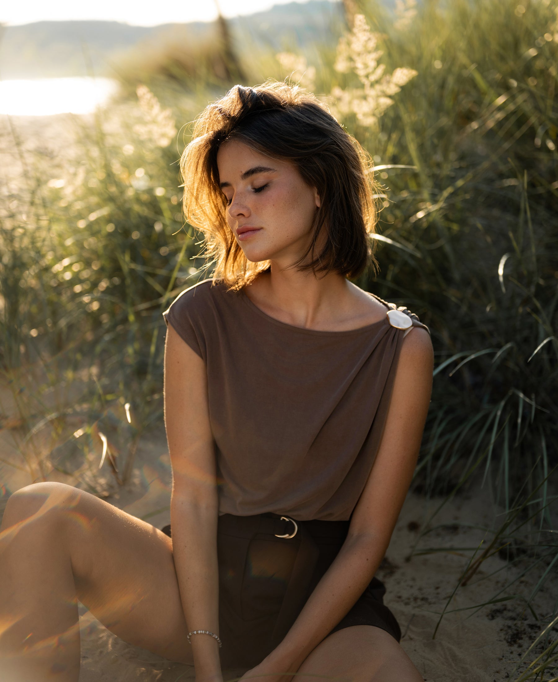 Brown LA MAYA top with buckle from PLEIN PUBLIQUE shown in sunlight.