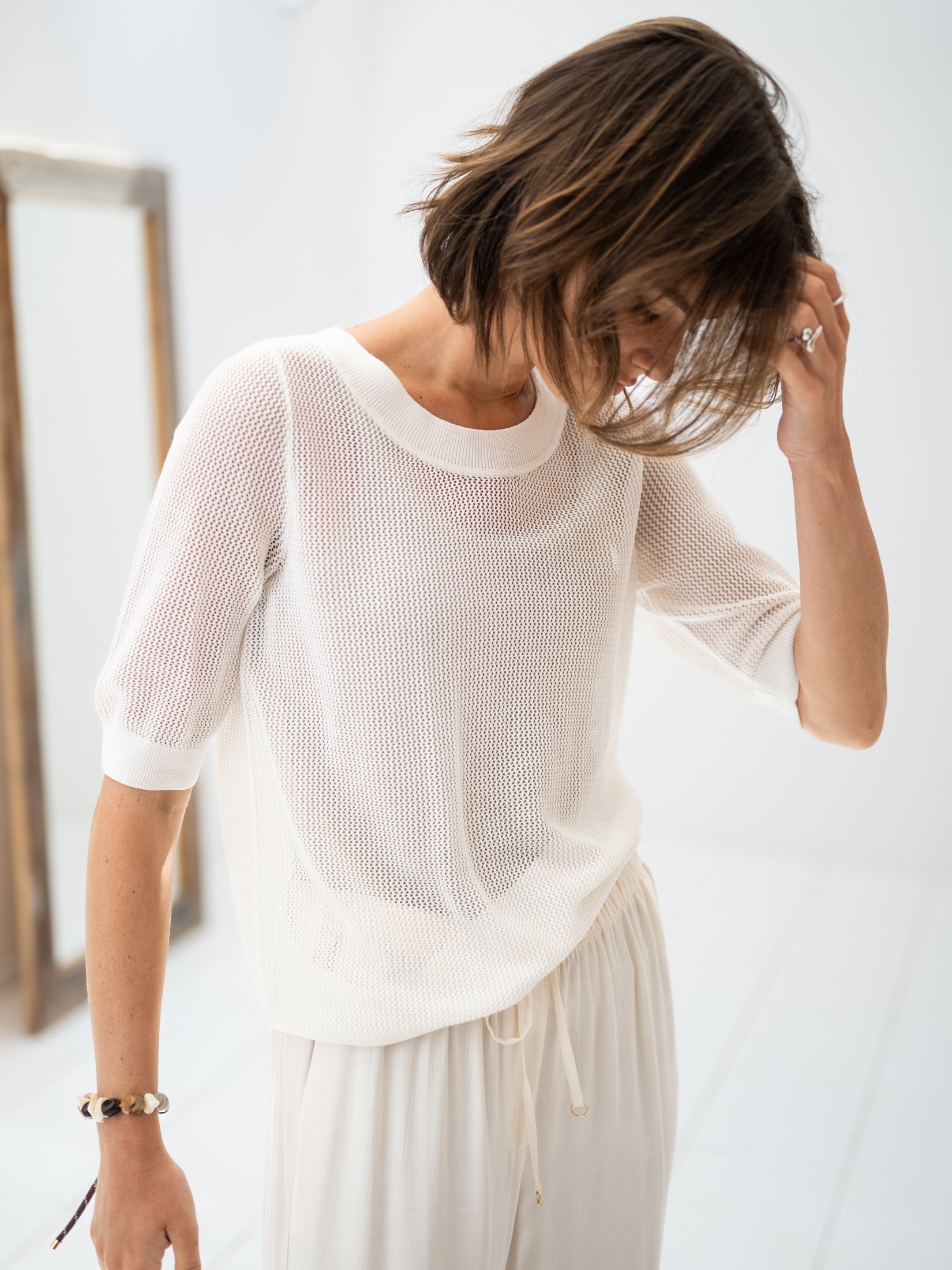 PLEIN PUBLIQUE white mesh sweater with silk, shown indoors on a model touching her hair.