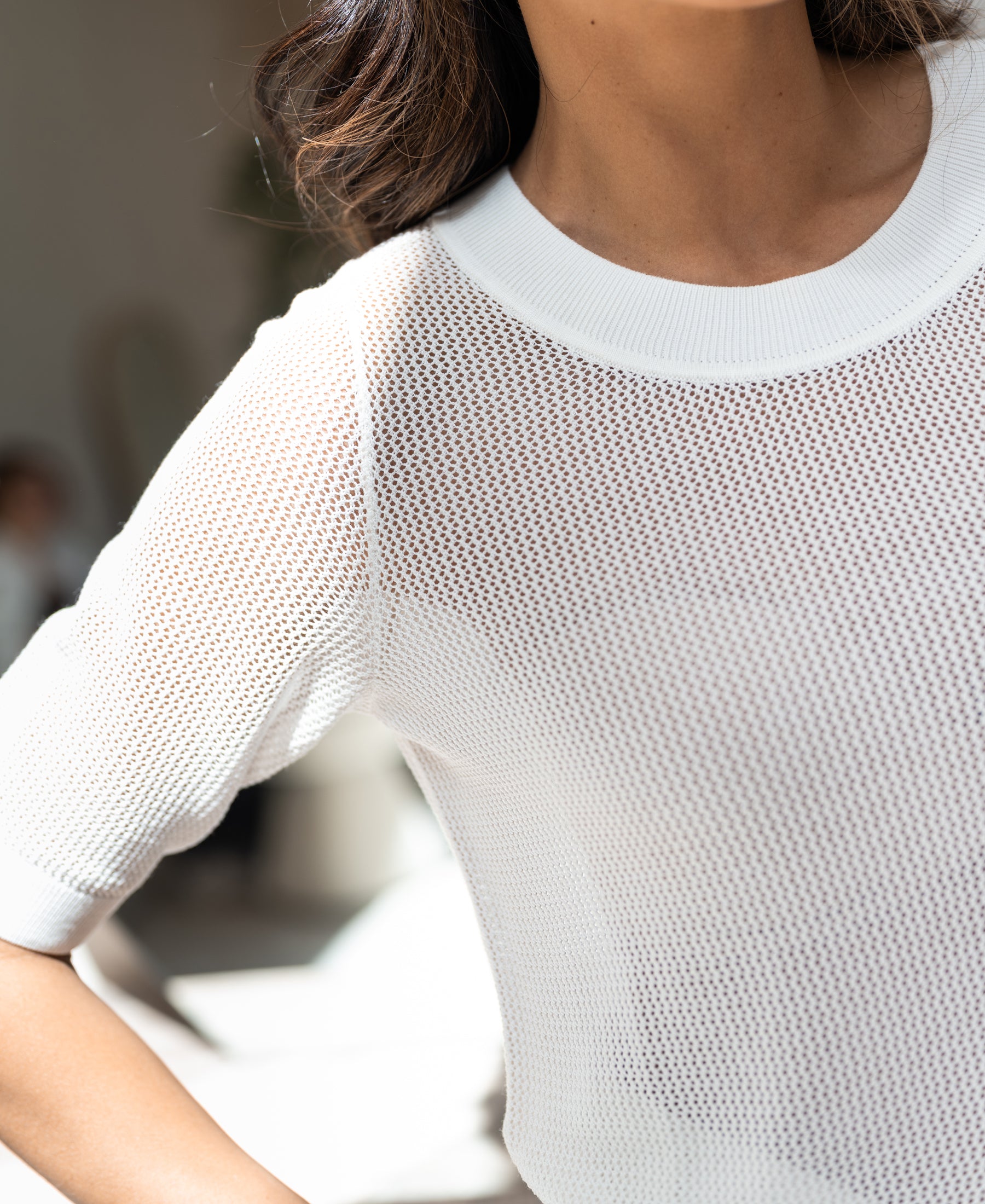 Short-sleeved white mesh sweater with silk, shown in bright natural light.