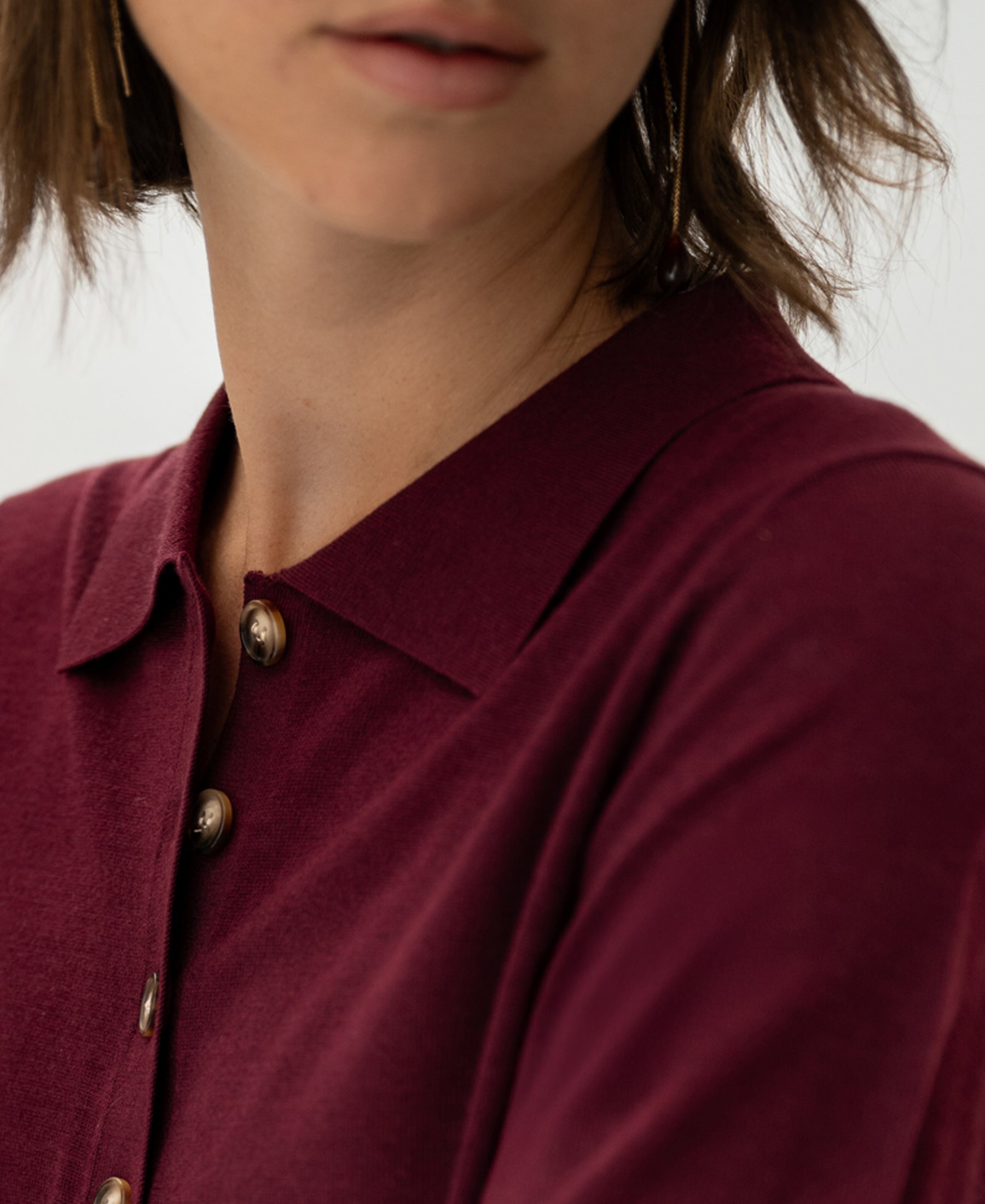 Merino wool-silk polo shirt in wine color, shown from shoulders up, facing slightly to the side.