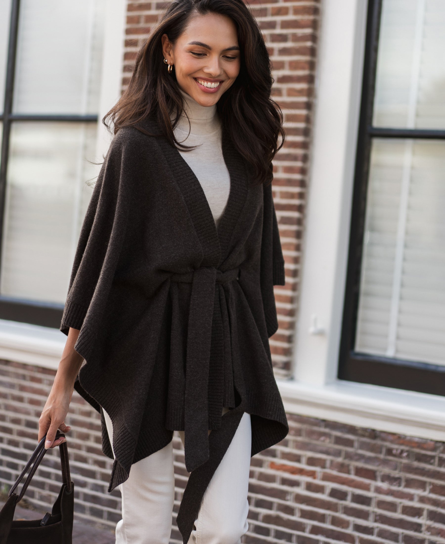 Woman outdoors wearing a chocolate brown pure merino wool poncho.