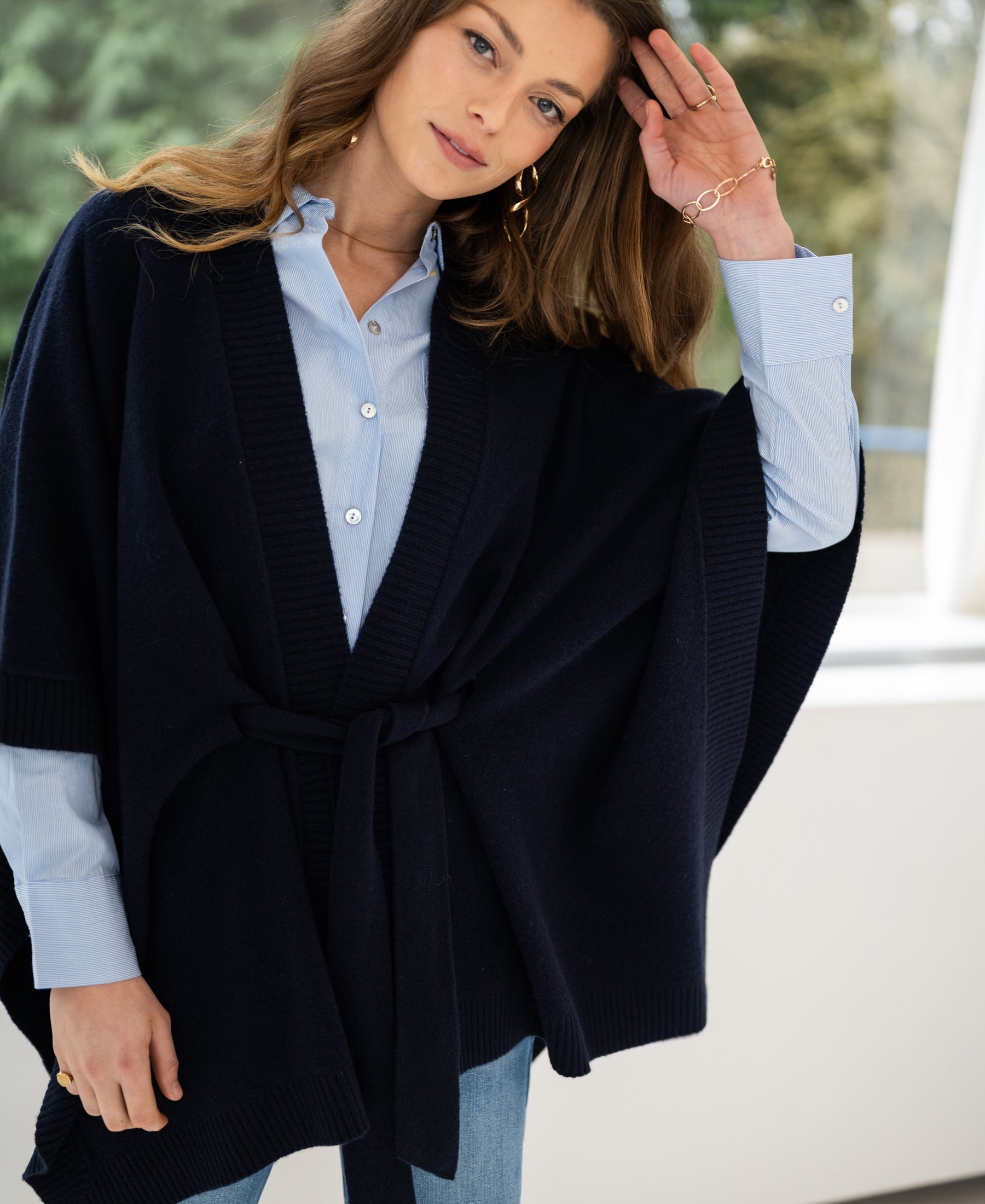 Navy blue merino wool poncho shown indoors.