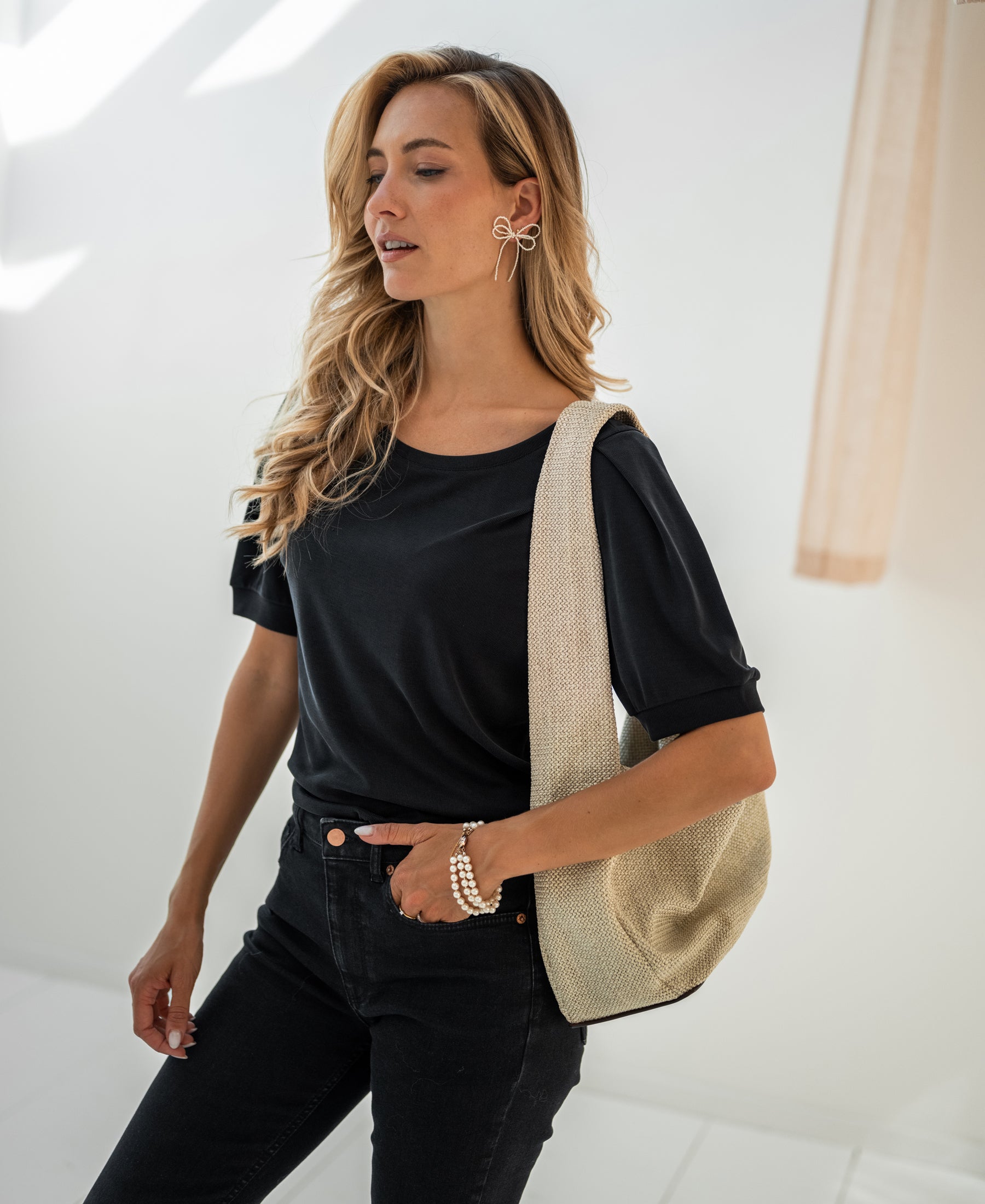 Woman wearing a charcoal ribbed T-shirt indoors.