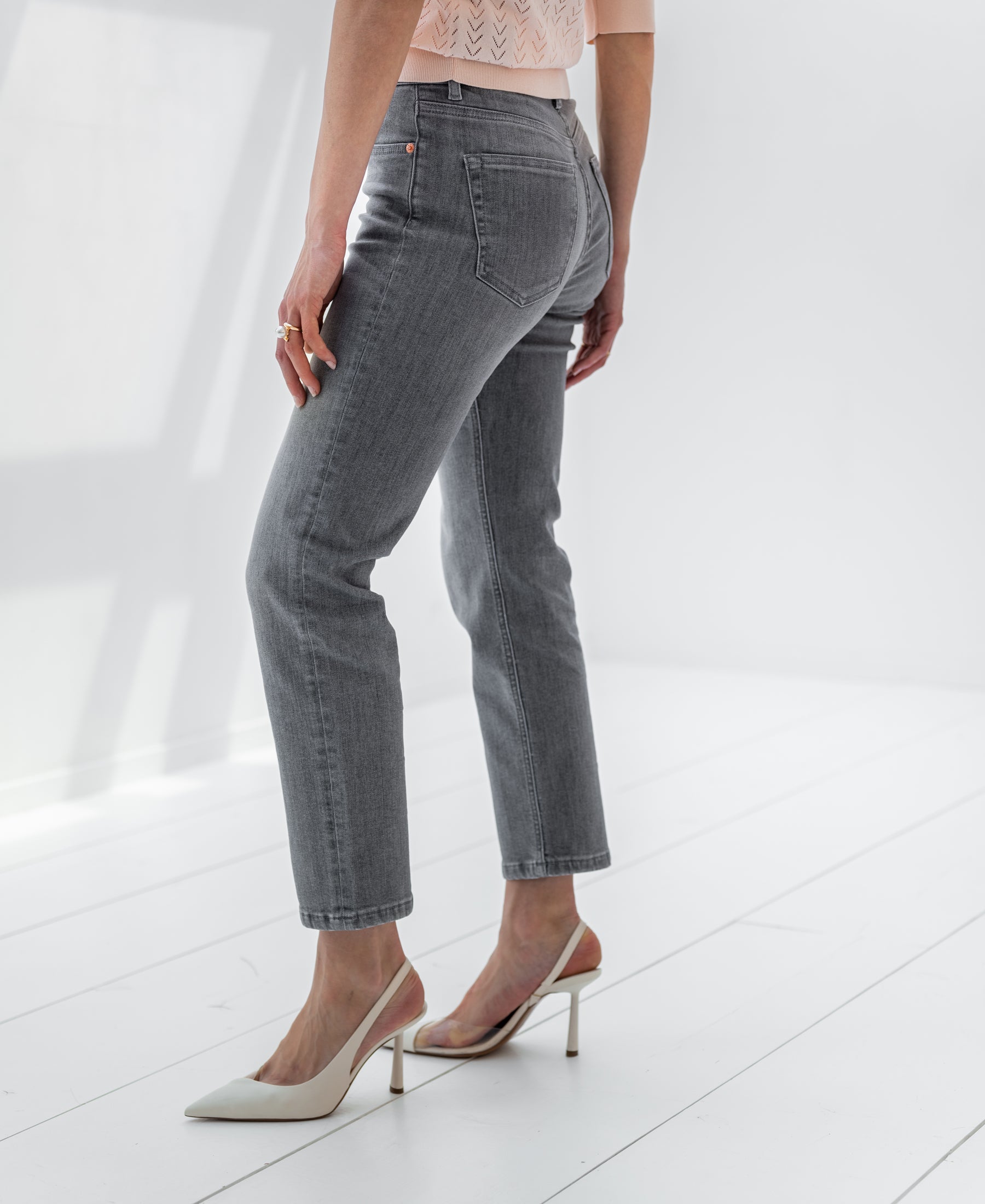 Cropped grey stonewash jeans, waist to feet view.