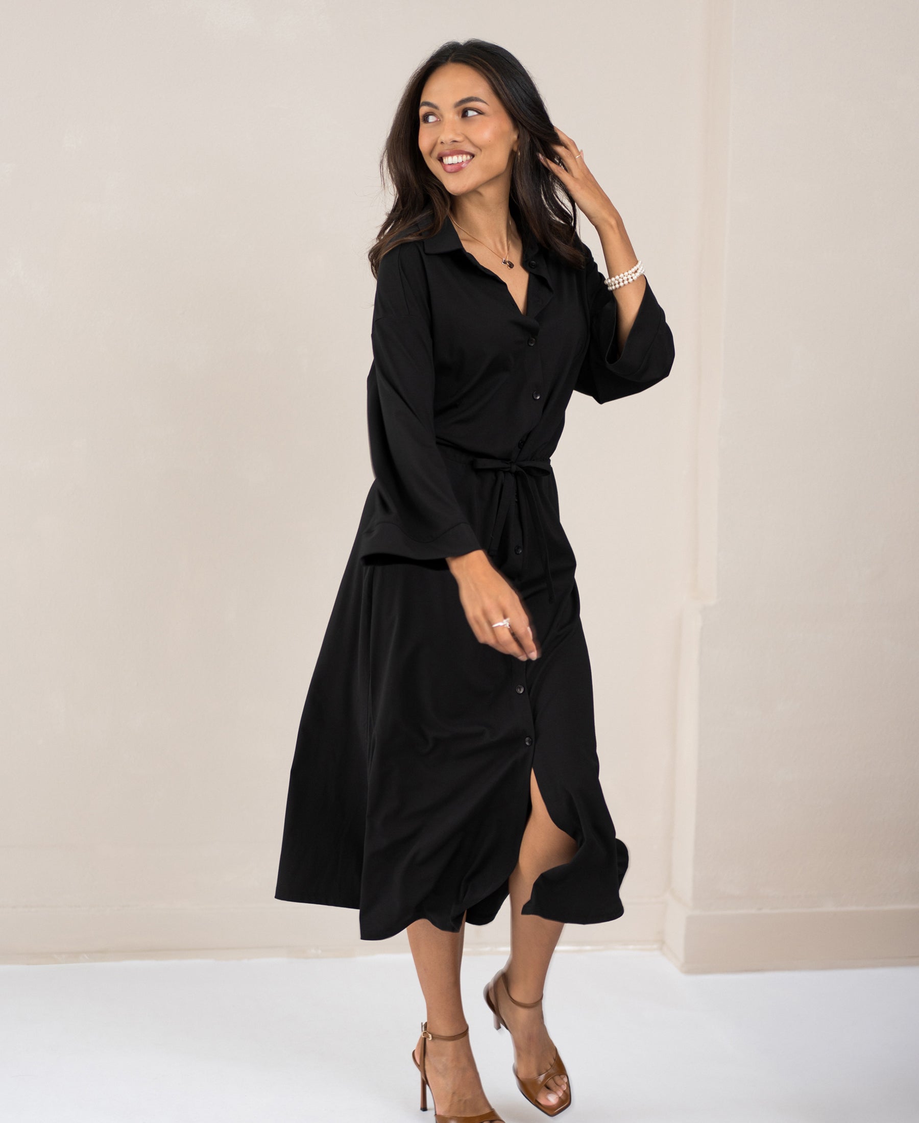 Woman wearing a black button-down dress from PLEIN PUBLIQUE, front view.