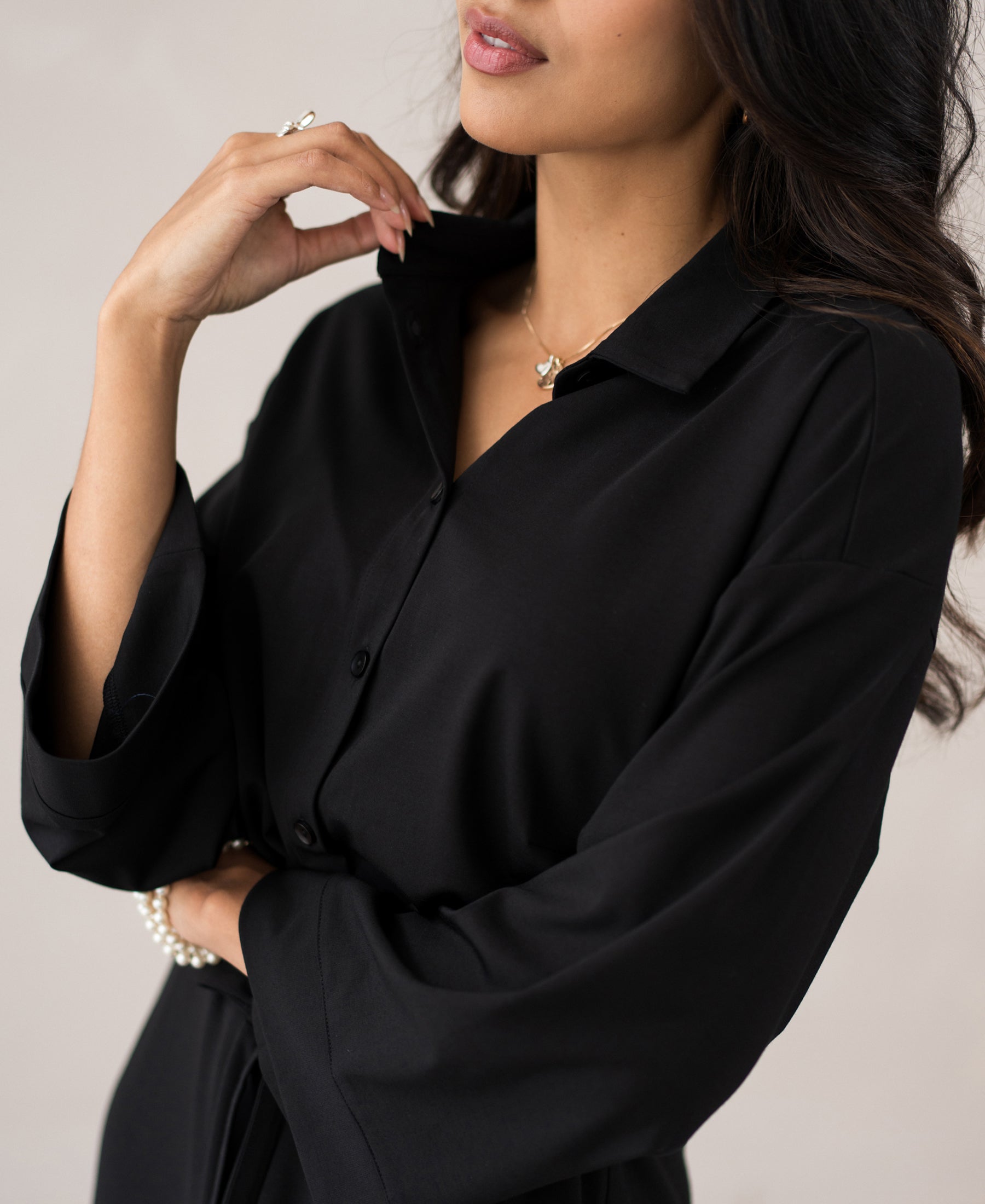 Woman wearing the LE RAPHAEL black button-down dress by PLEIN PUBLIQUE.