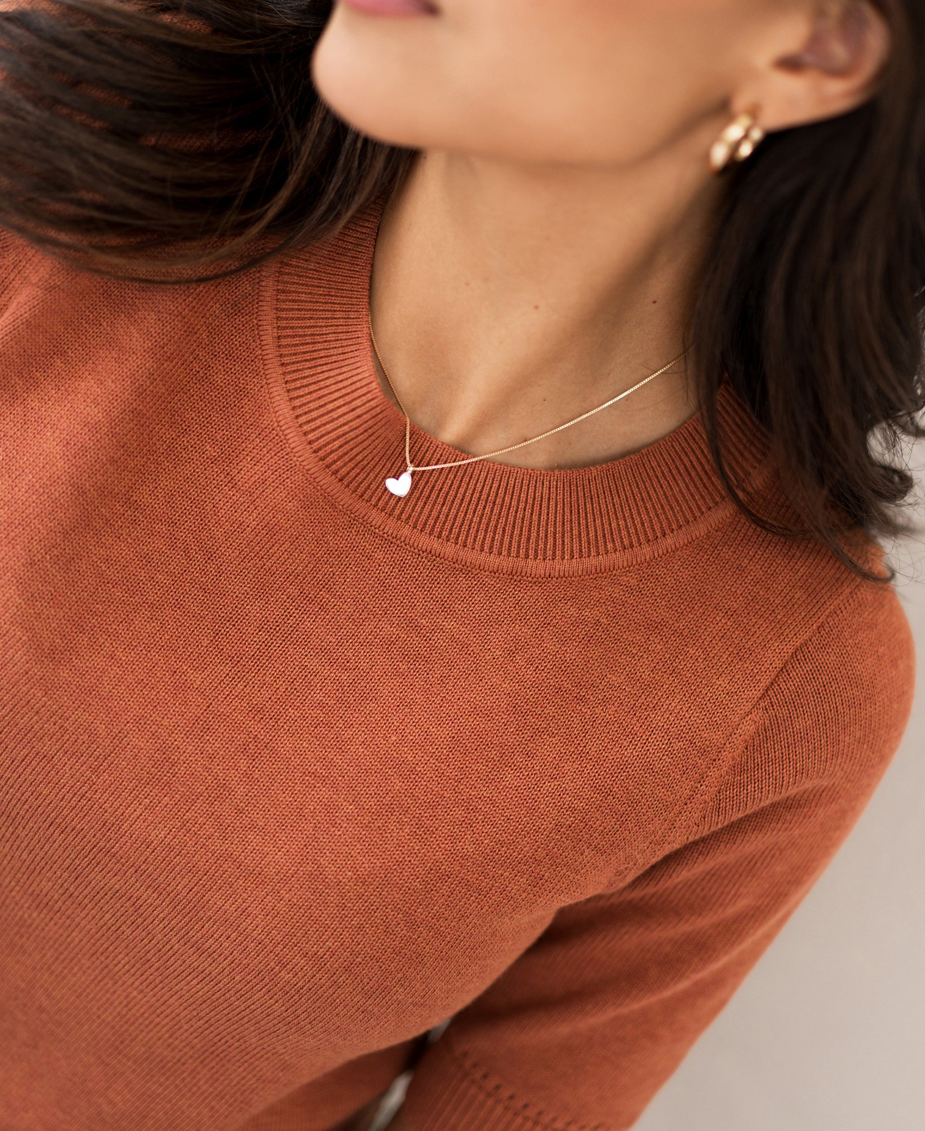 Woman wearing a caramel-colored sweater.