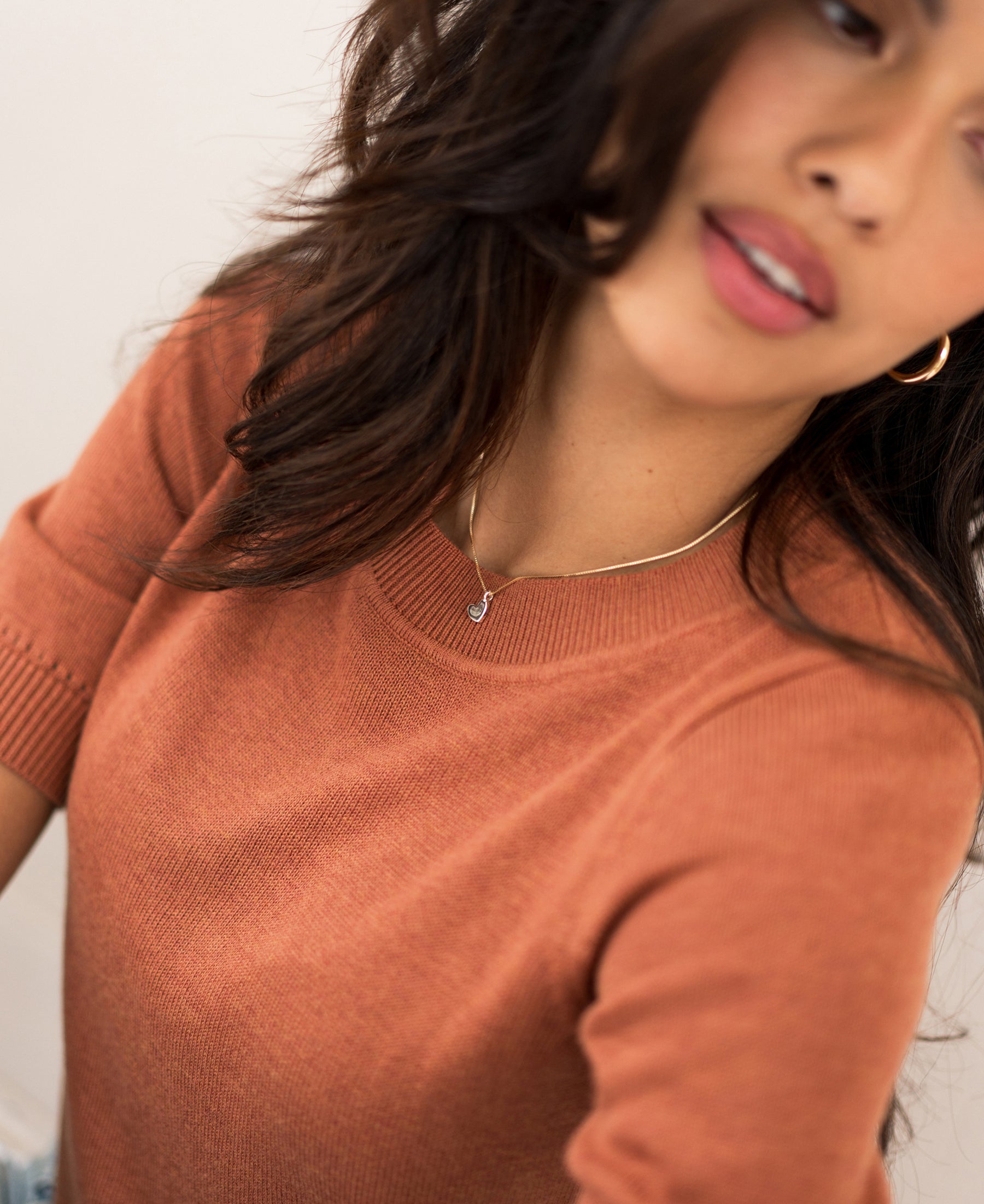 Woman wearing a caramel-colored PLEIN PUBLIQUE LA REVE sweater.