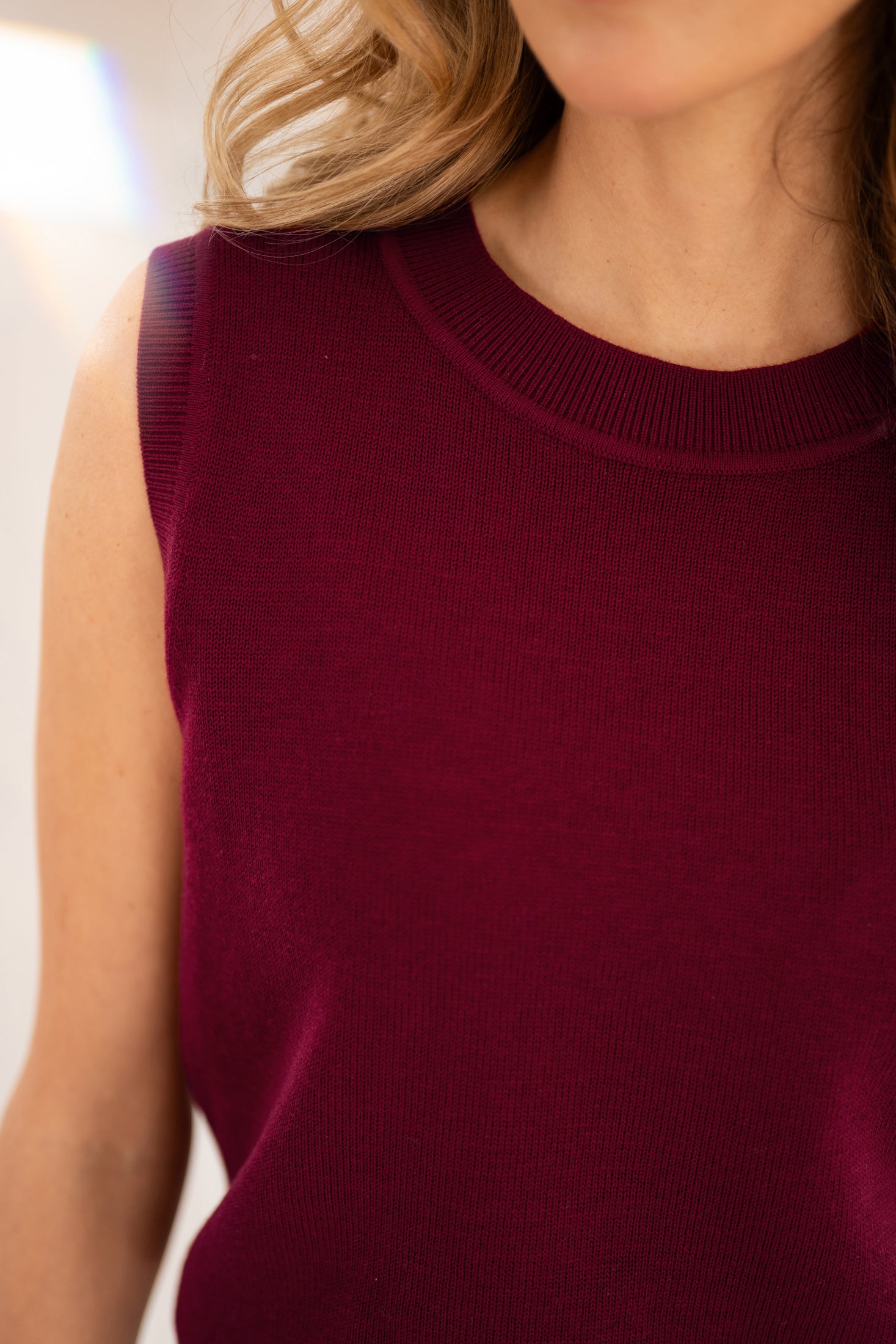 Dark red LE REVEIL cardigan by PLEIN PUBLIQUE; neck, shoulders, and part of face visible.