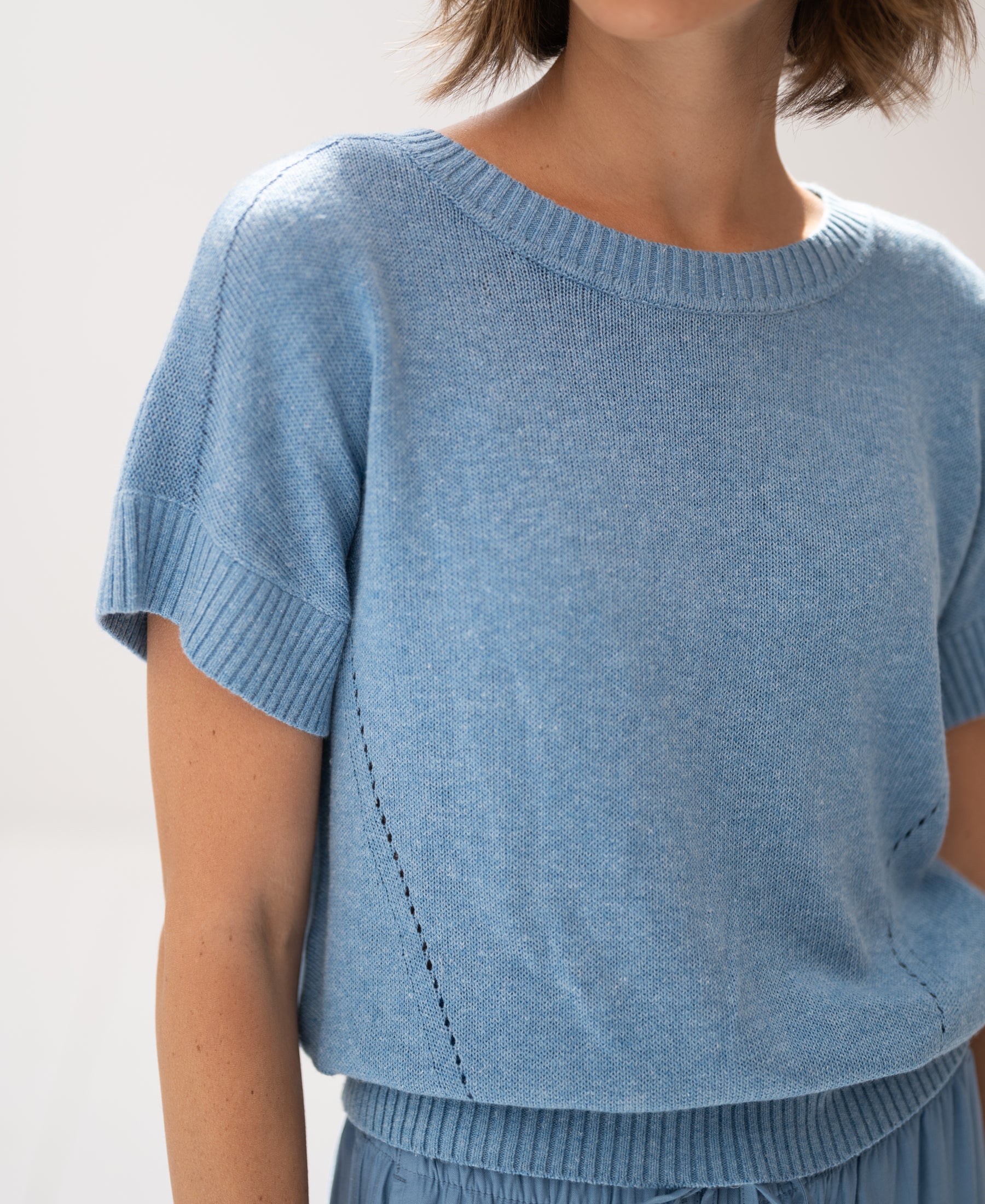 Light blue linen summer sweater shown from the shoulders.