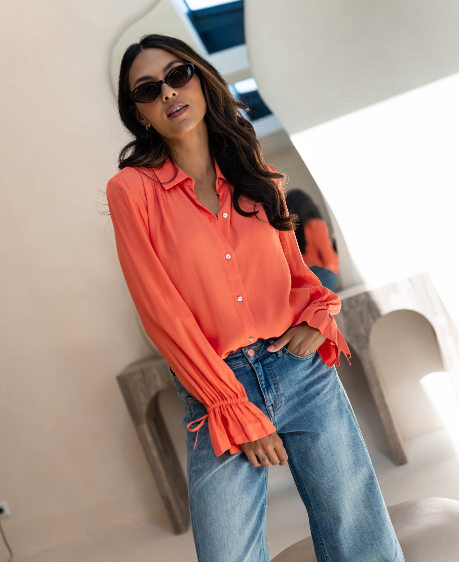 Coral PLEIN PUBLIQUE LA TROYES blouse shown indoors.