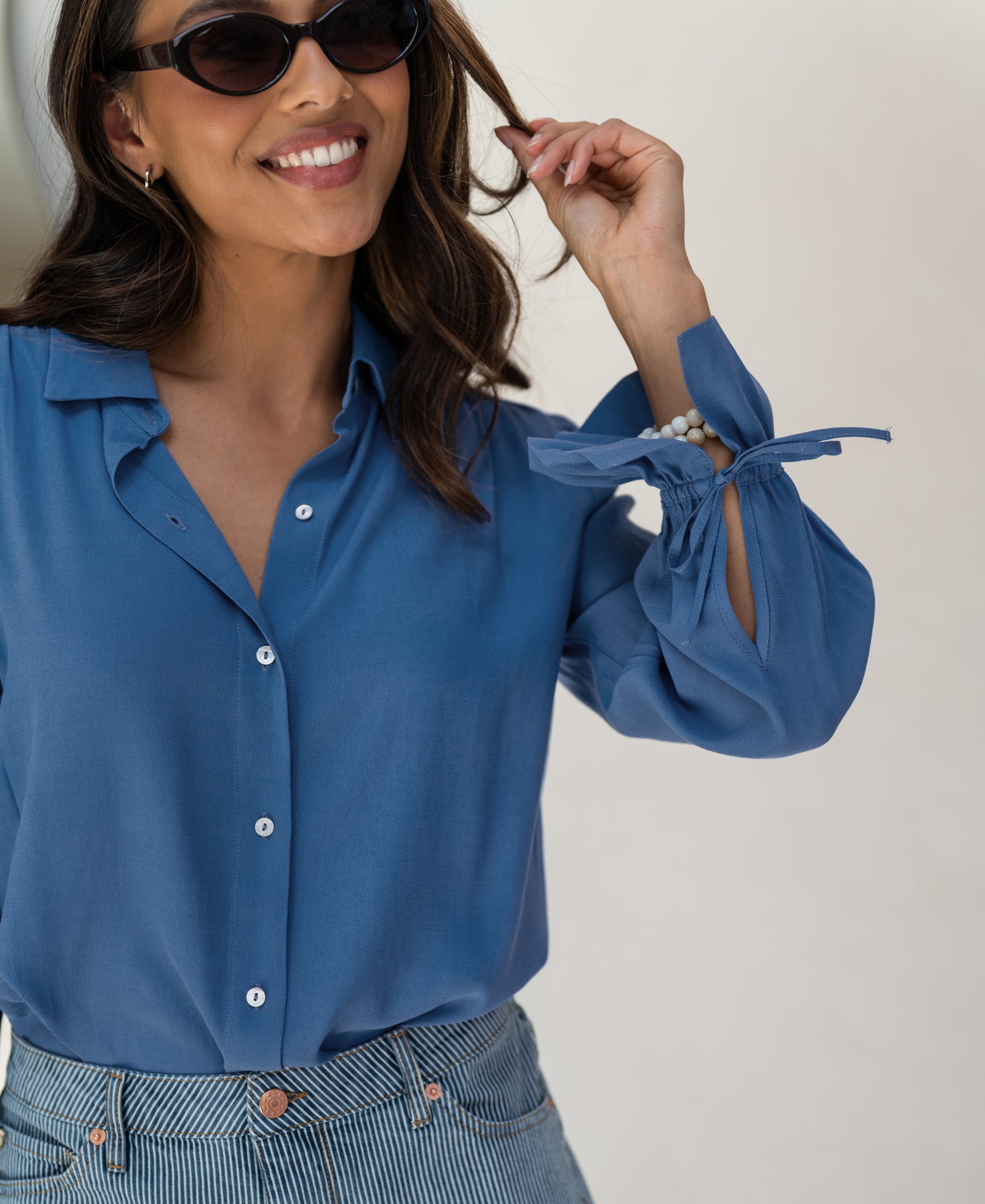 Woman wearing the PLEIN PUBLIQUE blue blouse LA TROYES.