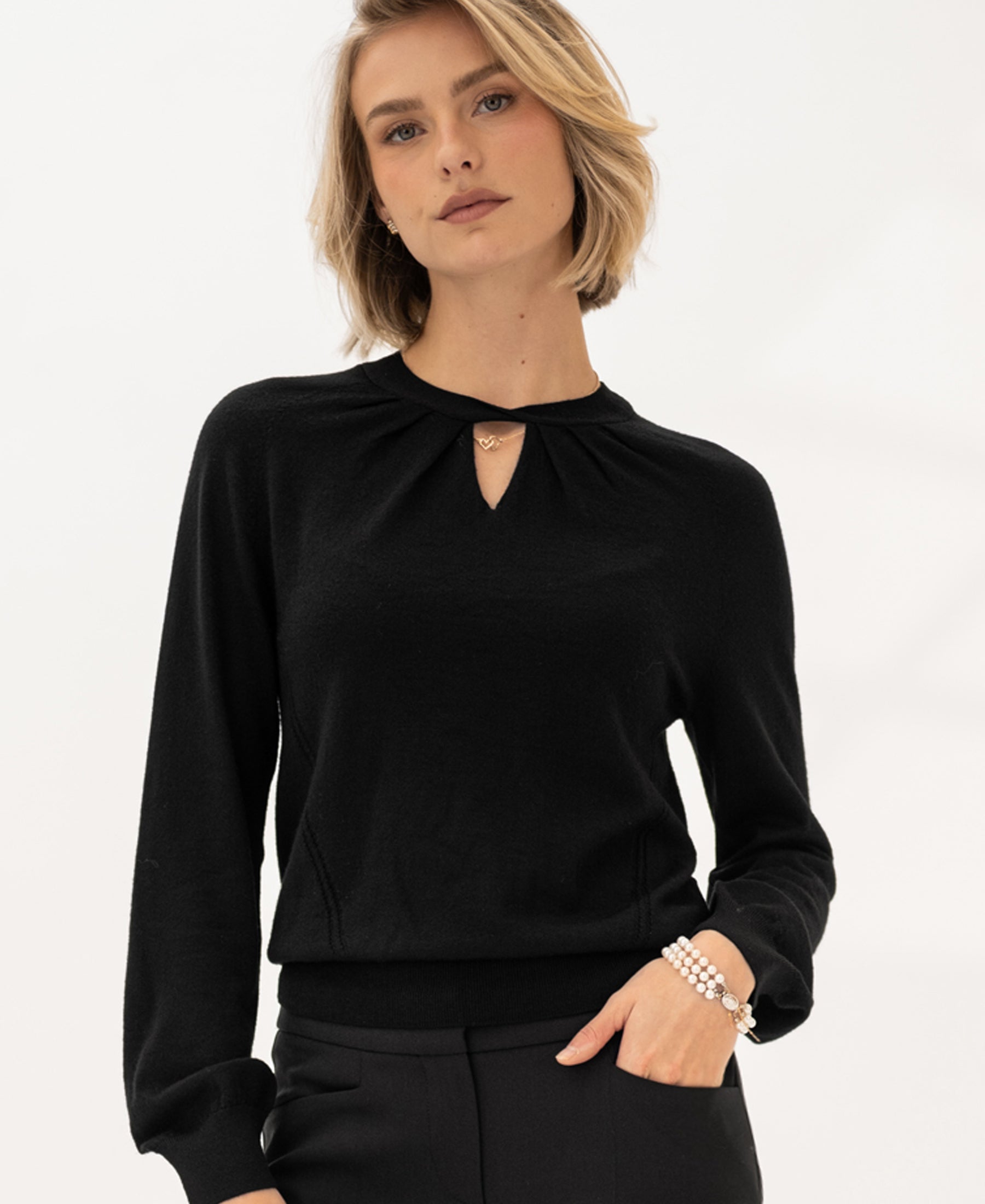 Woman wears the PLEIN PUBLIQUE Merino wool sweater LA TWIST in black.