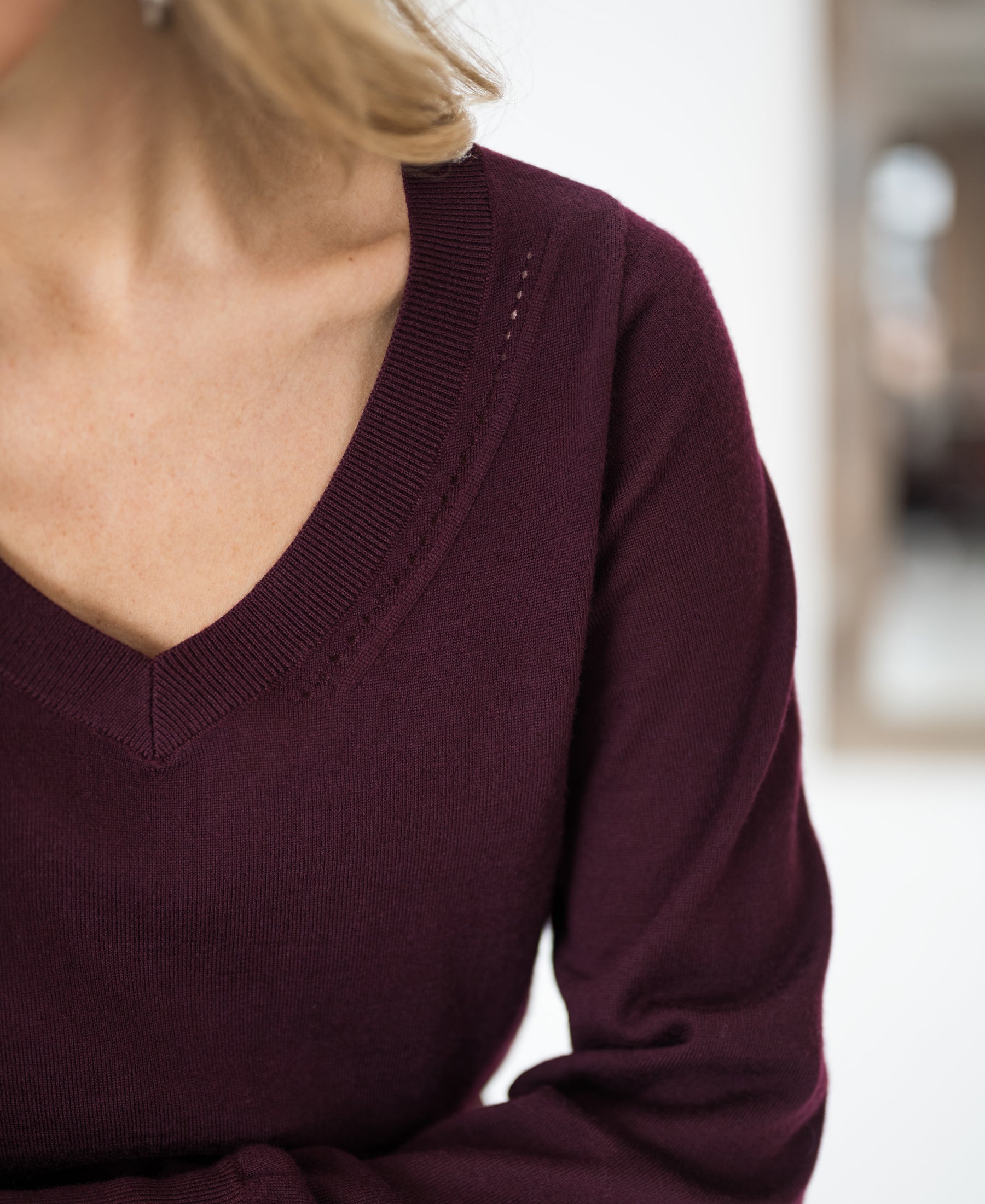 Merino wool V-neck sweater in Bordeaux red, shown from shoulders to mid-torso.