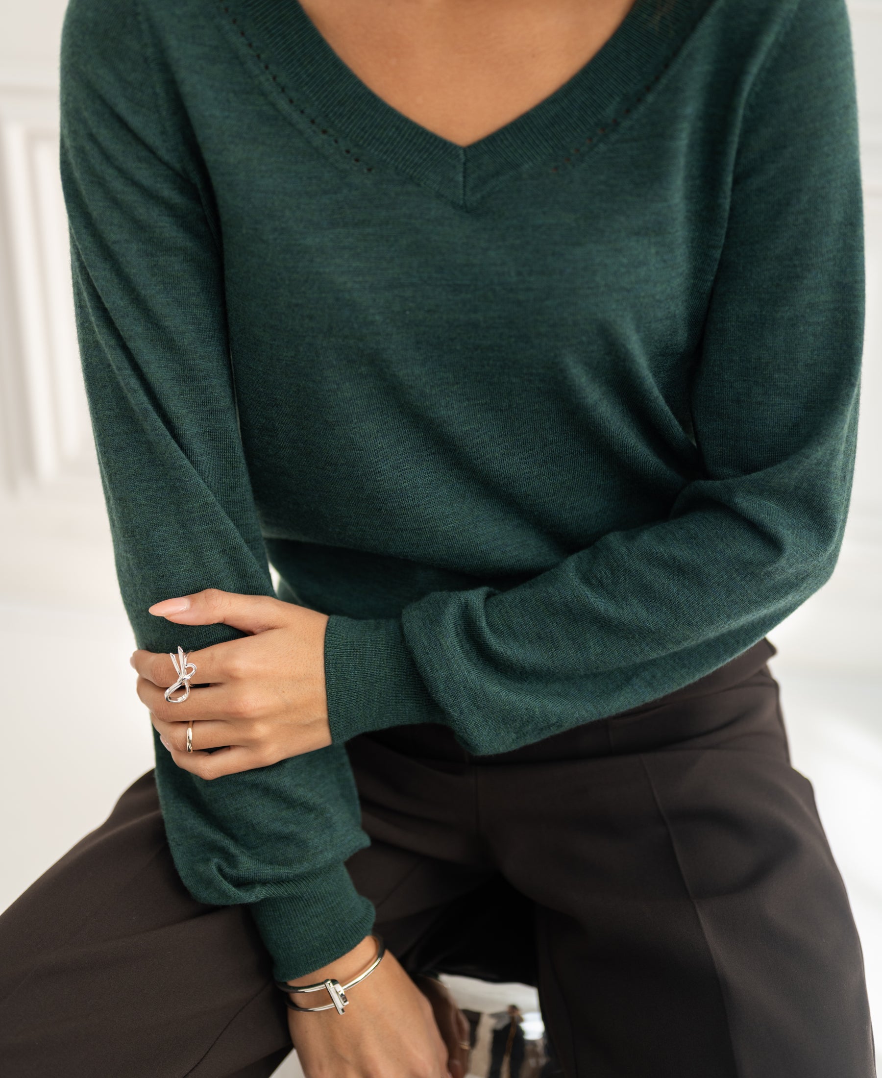 Person wears a PLEIN PUBLIQUE Merino wool V-neck sweater in greenish color.