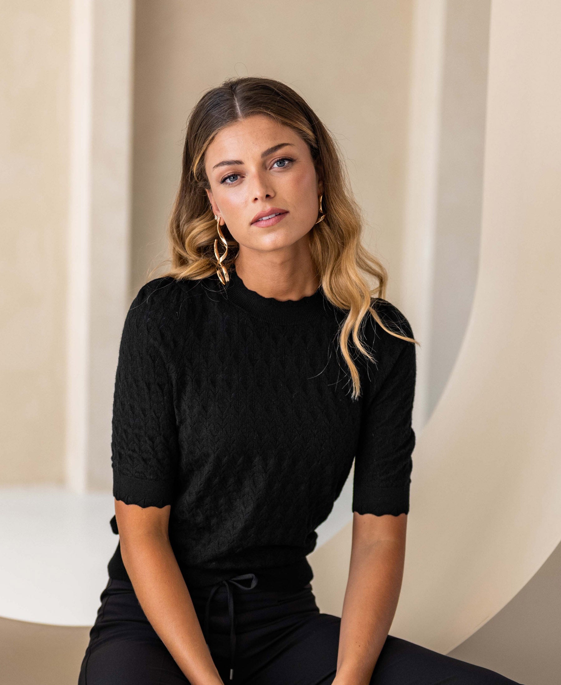 Black merino wool sweater LA BRIOCHE by PLEIN PUBLIQUE, shown against a light modern background.