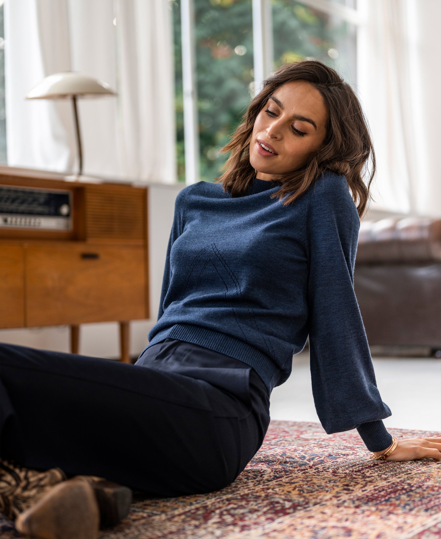 Blue denim turtleneck sweater by PLEIN PUBLIQUE displayed in a bright living room.